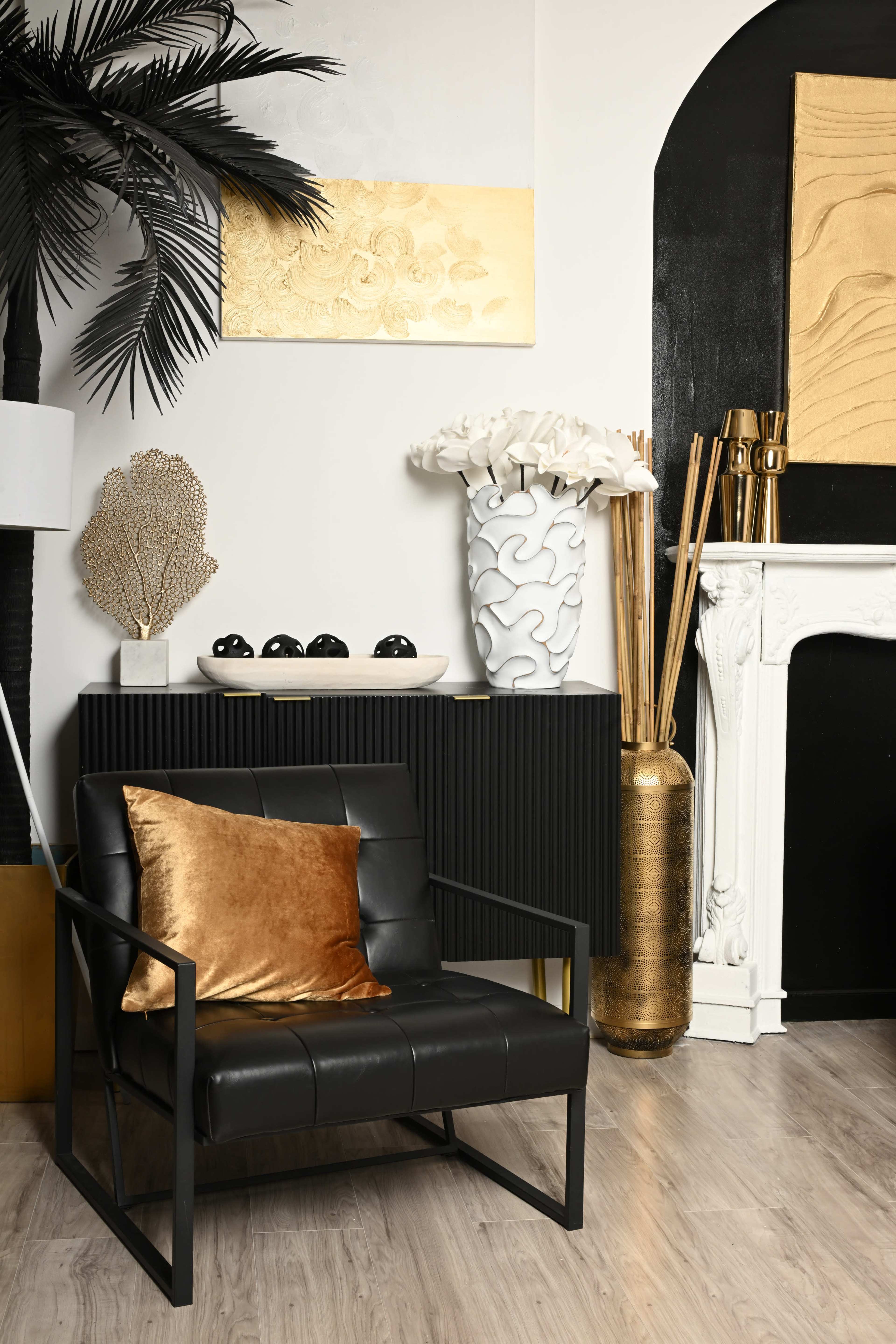 The image features a stylish interior scene with a black leather chair, a variety of decorative vases and sculptures, and a modern fireplace against a backdrop of contrasting colors and textures.