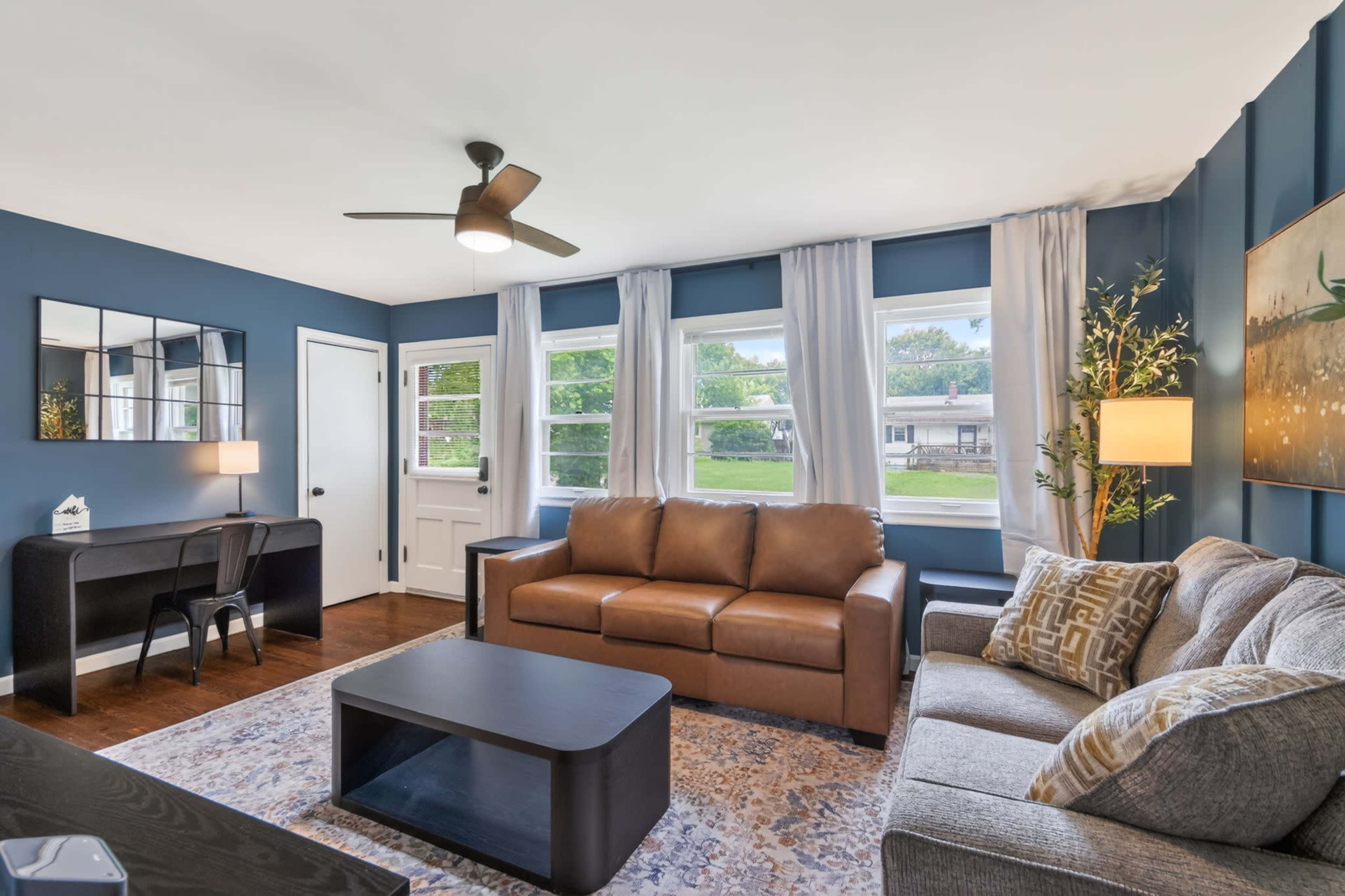 Moody Navy-Walled Bungalow with Bold Art & Backyard Image in Blue Township, Independence, MO