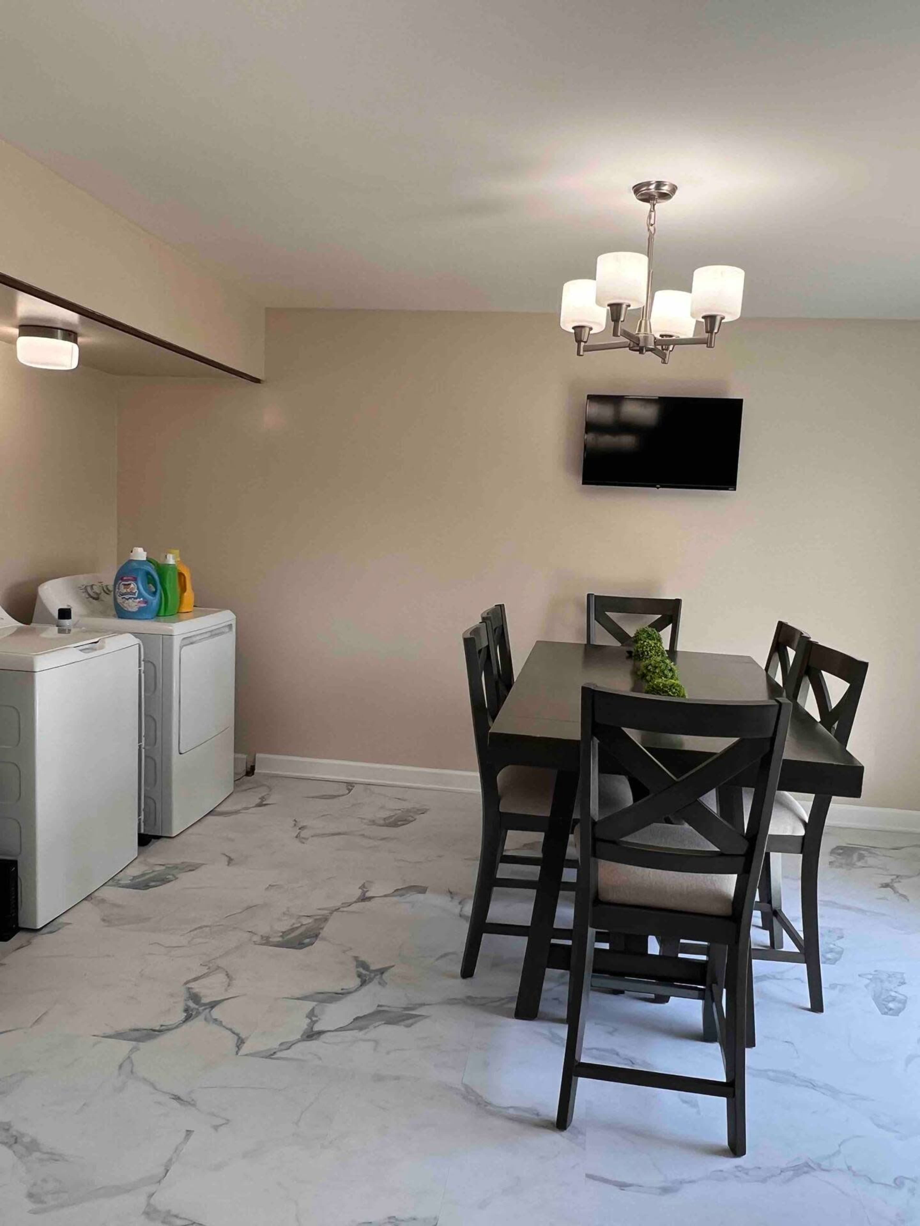 A dining area with a table and chairs, alongside a laundry area featuring a washing machine and dryer.