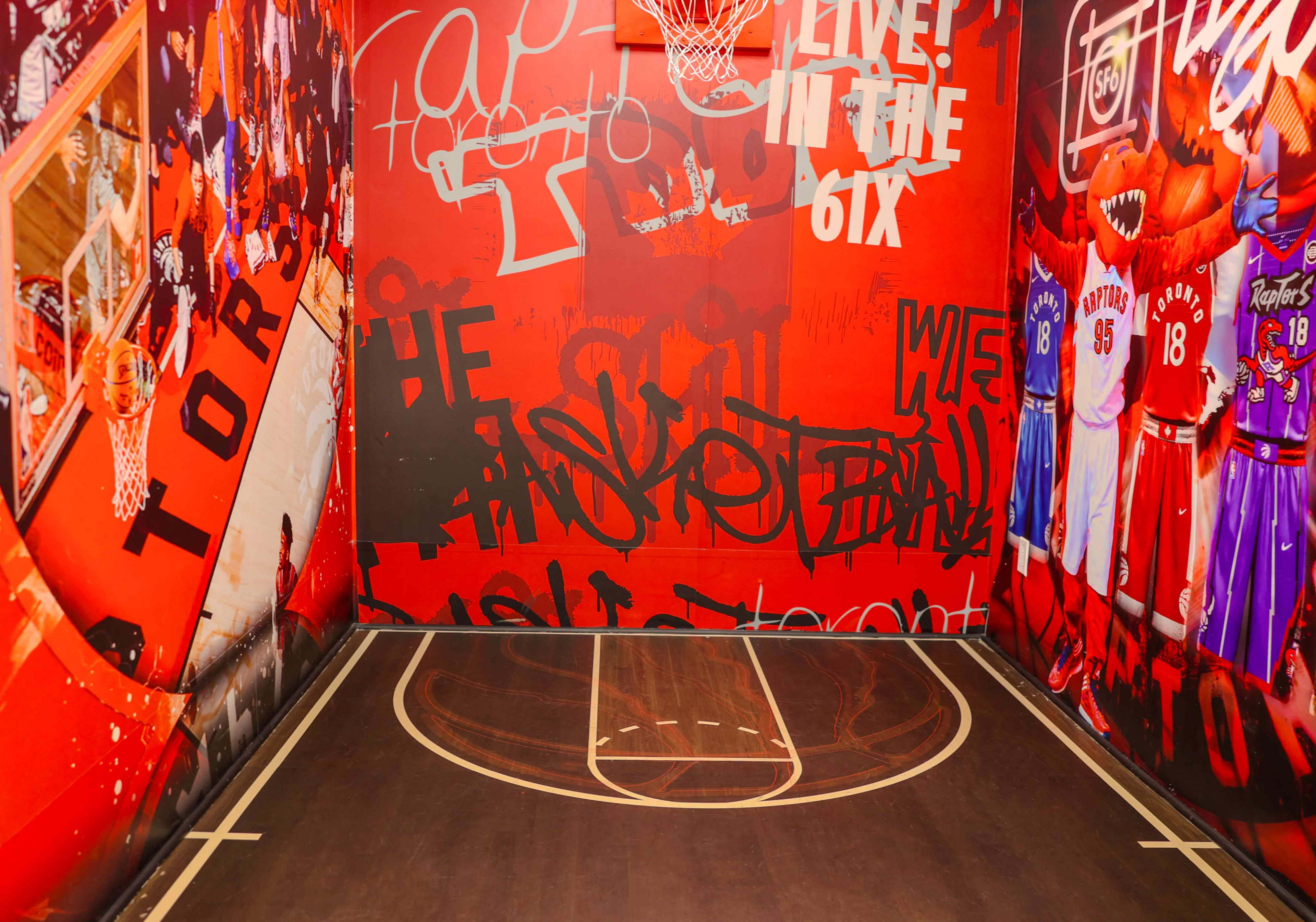 The image shows a vibrant basketball court enclosed by walls covered in colorful graffiti and imagery related to basketball culture.