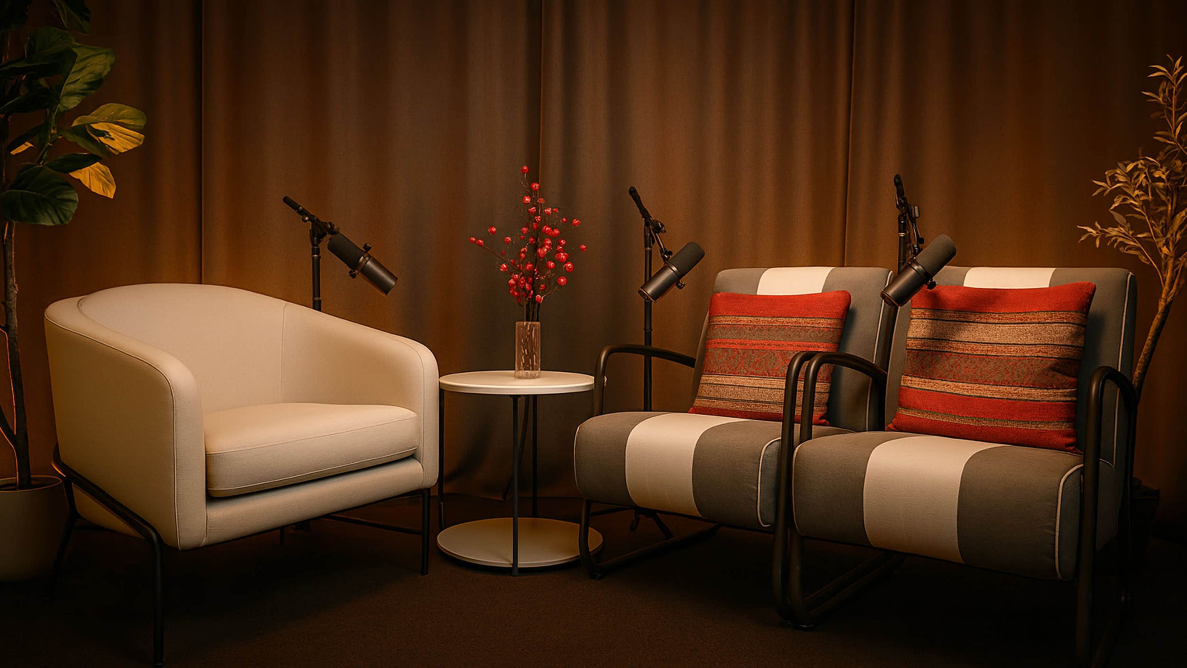 The image features a cozy seating arrangement with two armchairs and a small round table, adorned with a plant and a decorative vase.