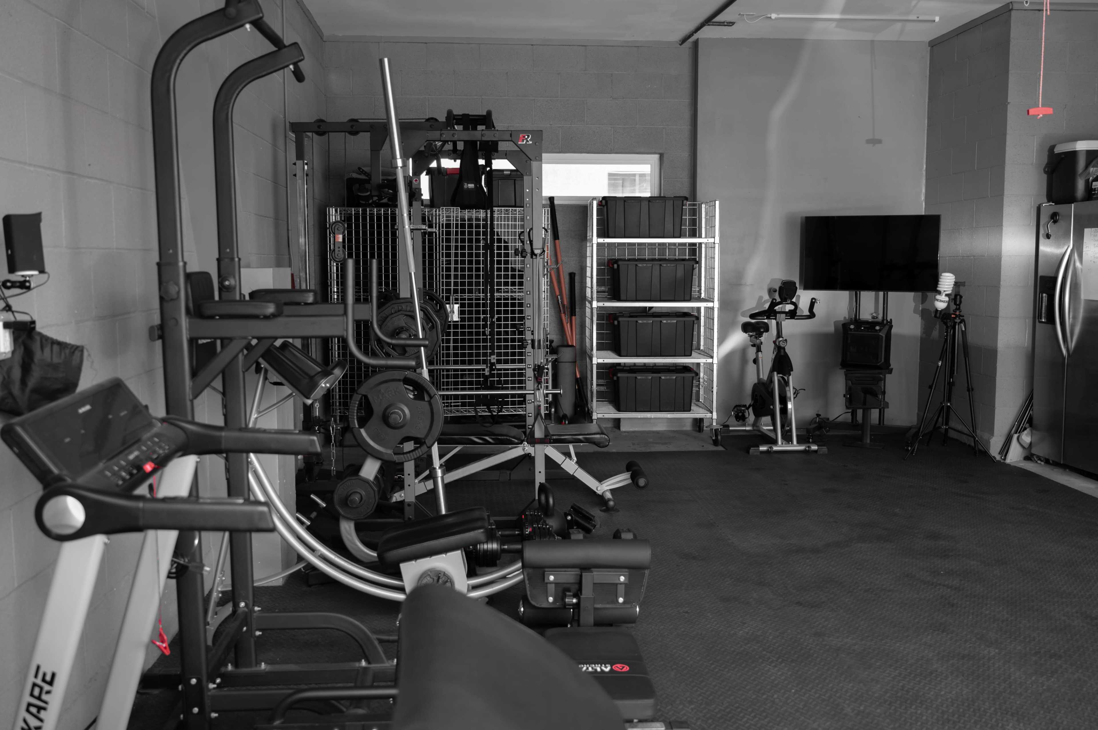 A home gym equipped with various exercise machines and storage units.