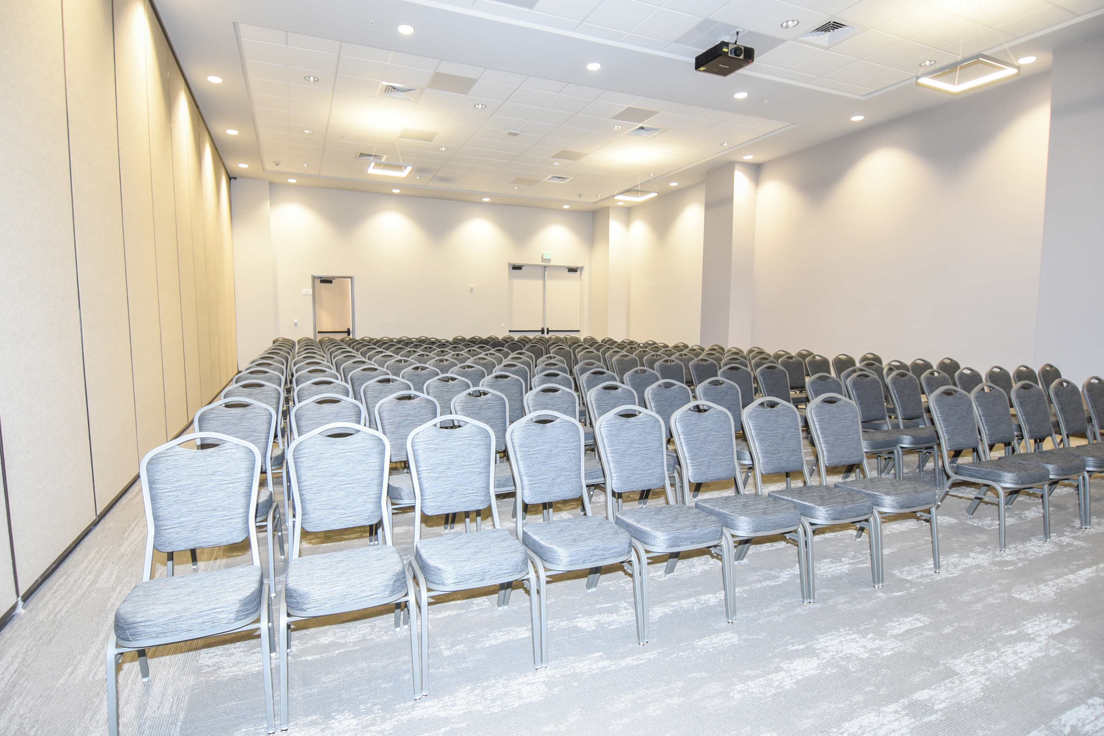 A row of gray chairs is neatly arranged in a conference room.