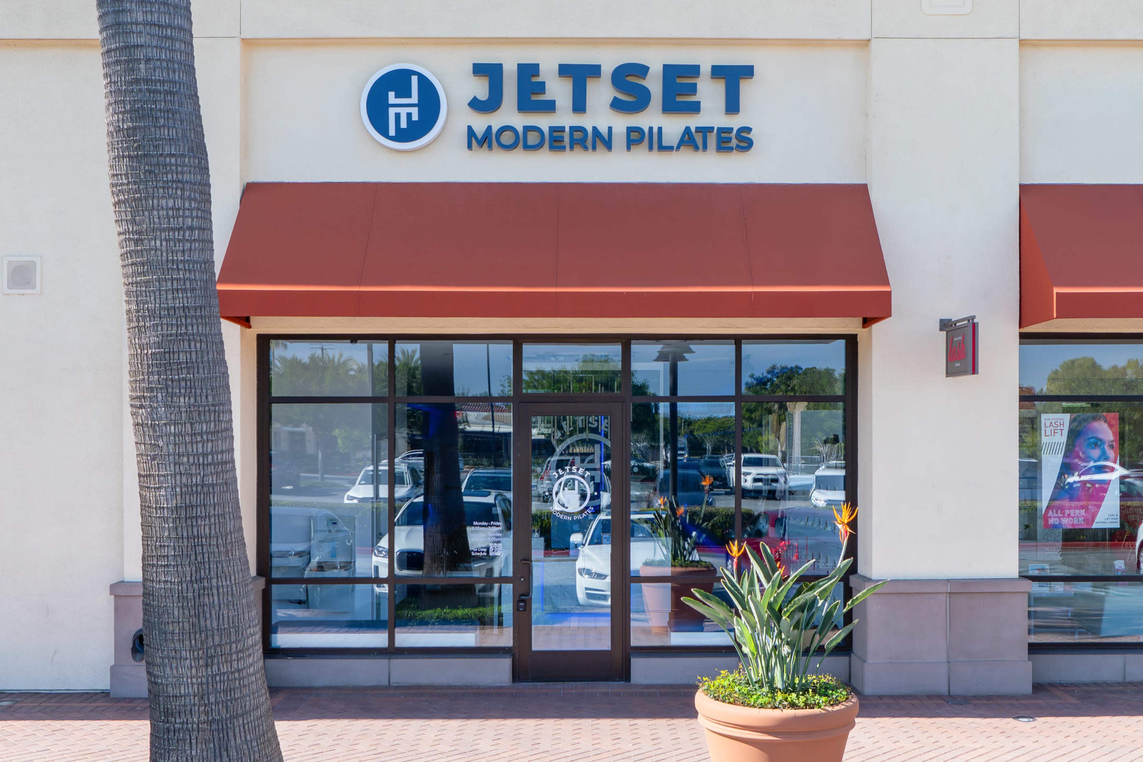 The image shows the storefront of Jetset Modern Pilates, featuring large windows and a sign above the entrance.