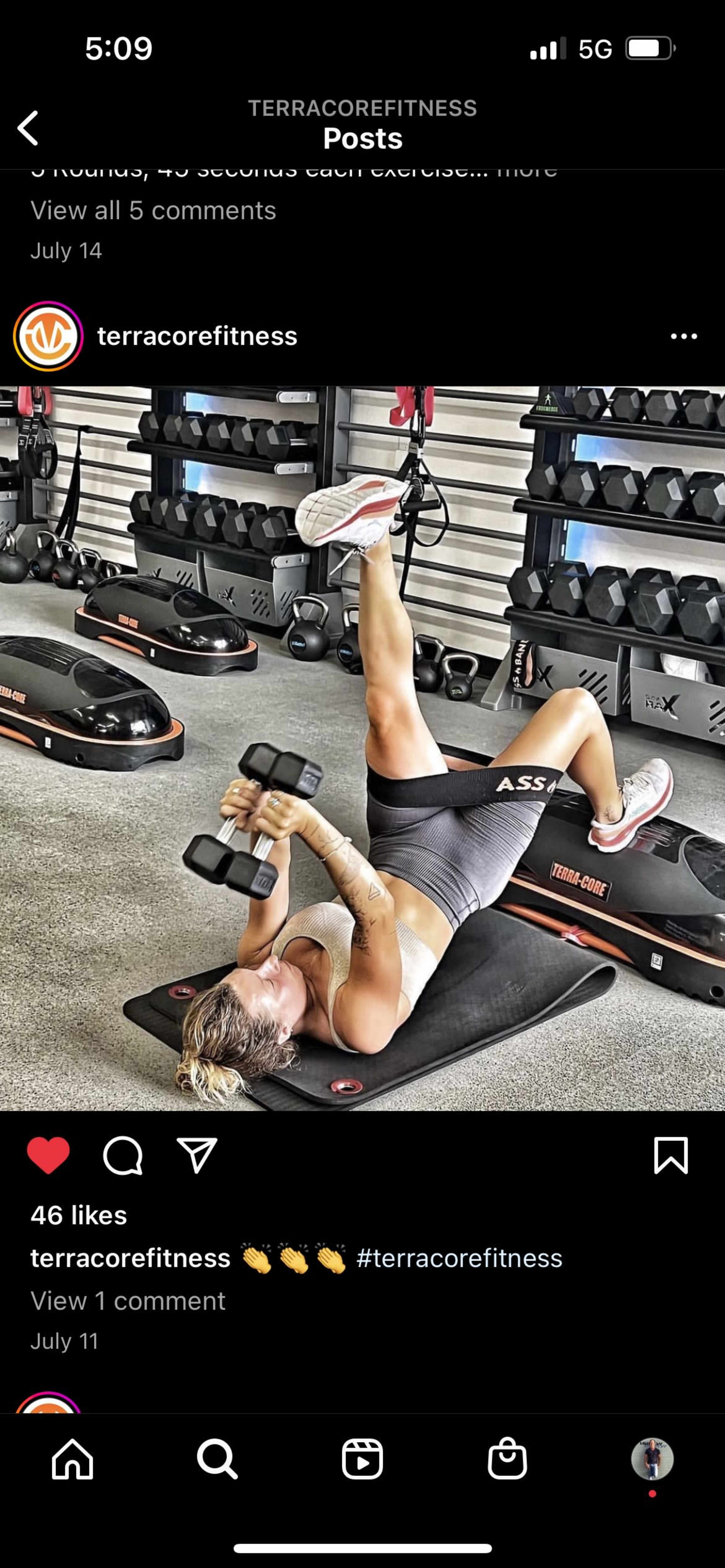 A person is performing an exercise on a gym mat, lying on their back and holding dumbbells.