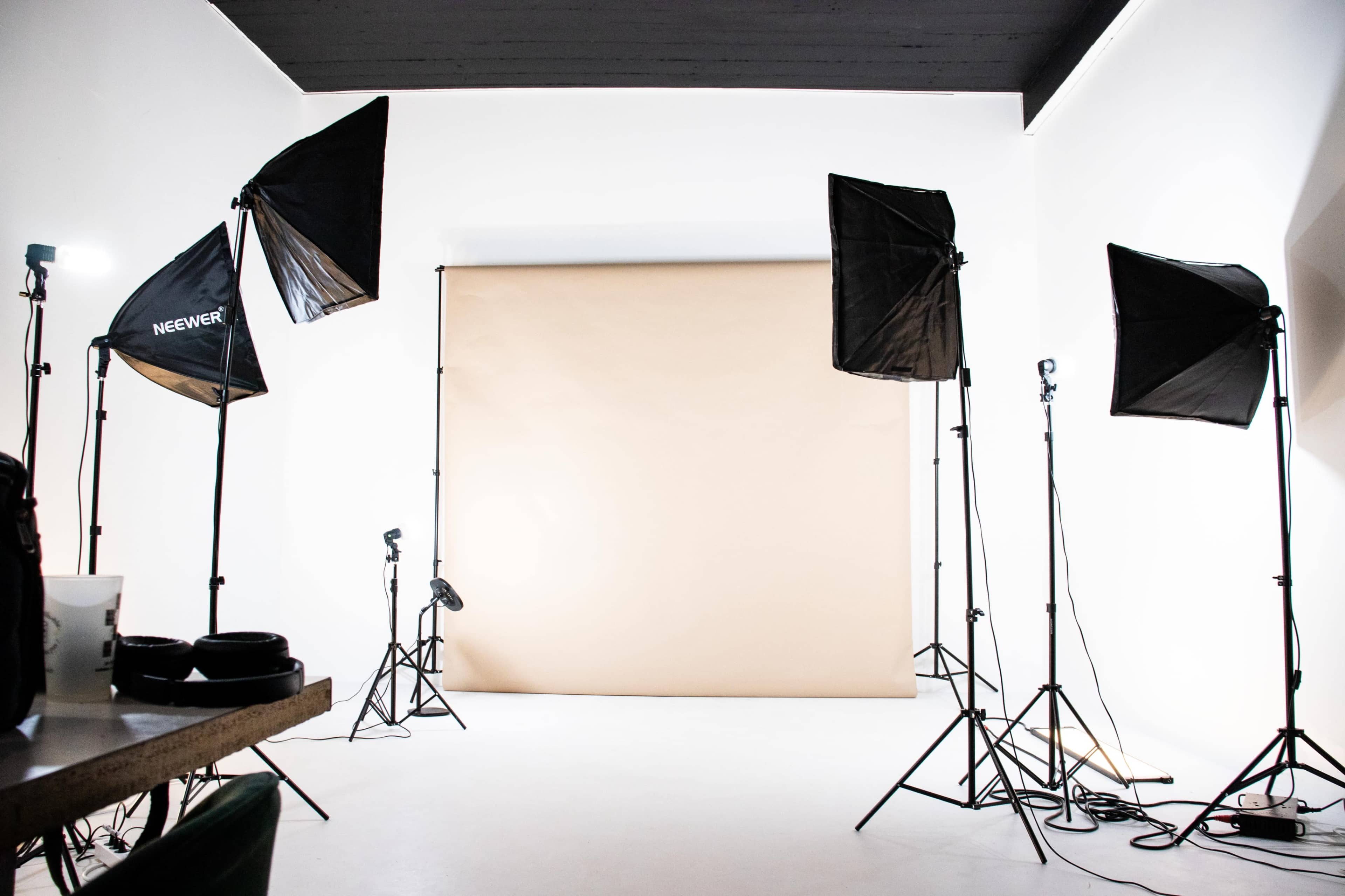 A photography studio is set up with multiple softbox lights and a seamless backdrop.