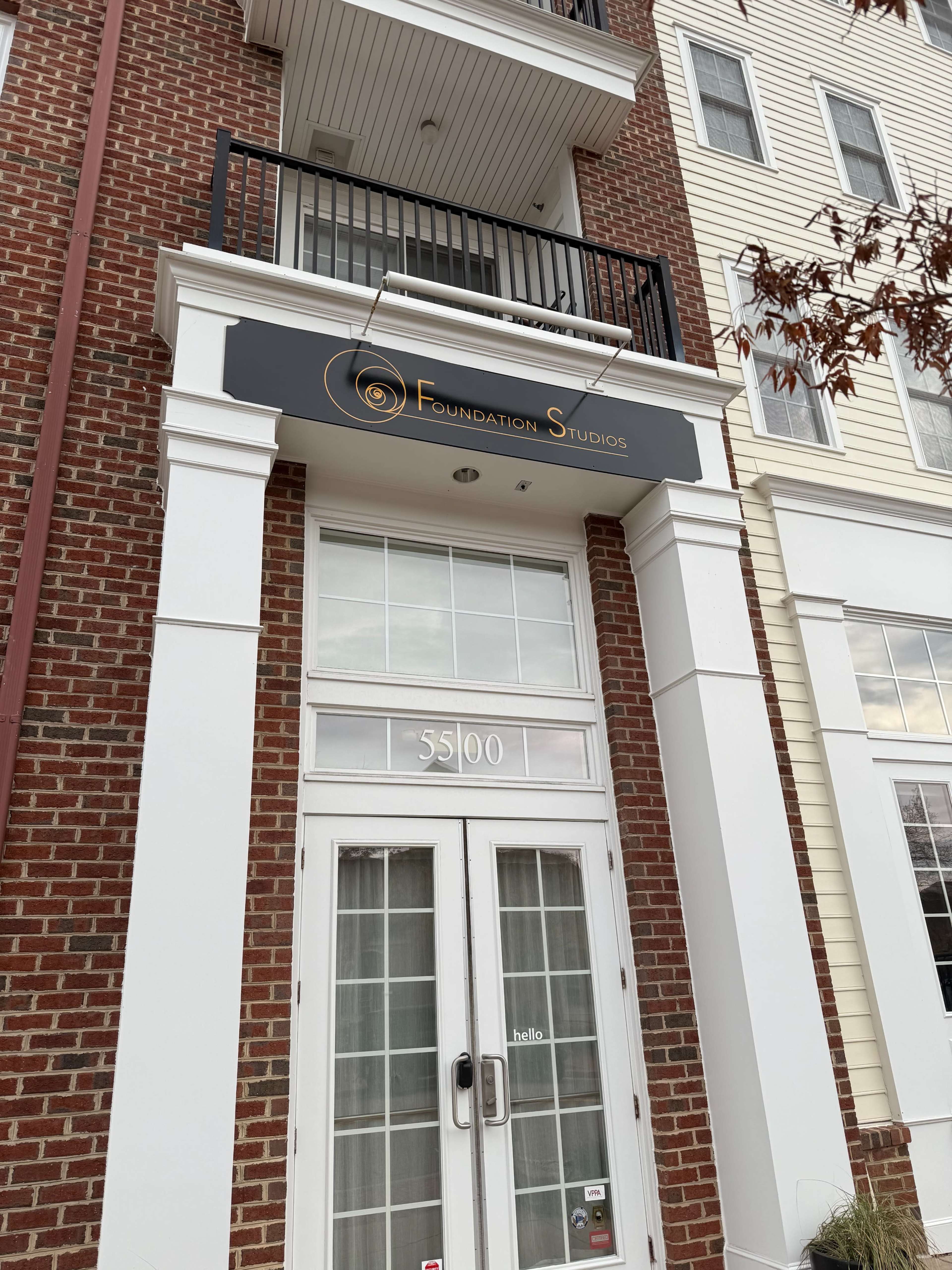The image shows the entrance of a building with a sign that reads "Foundation Studios" above the door.