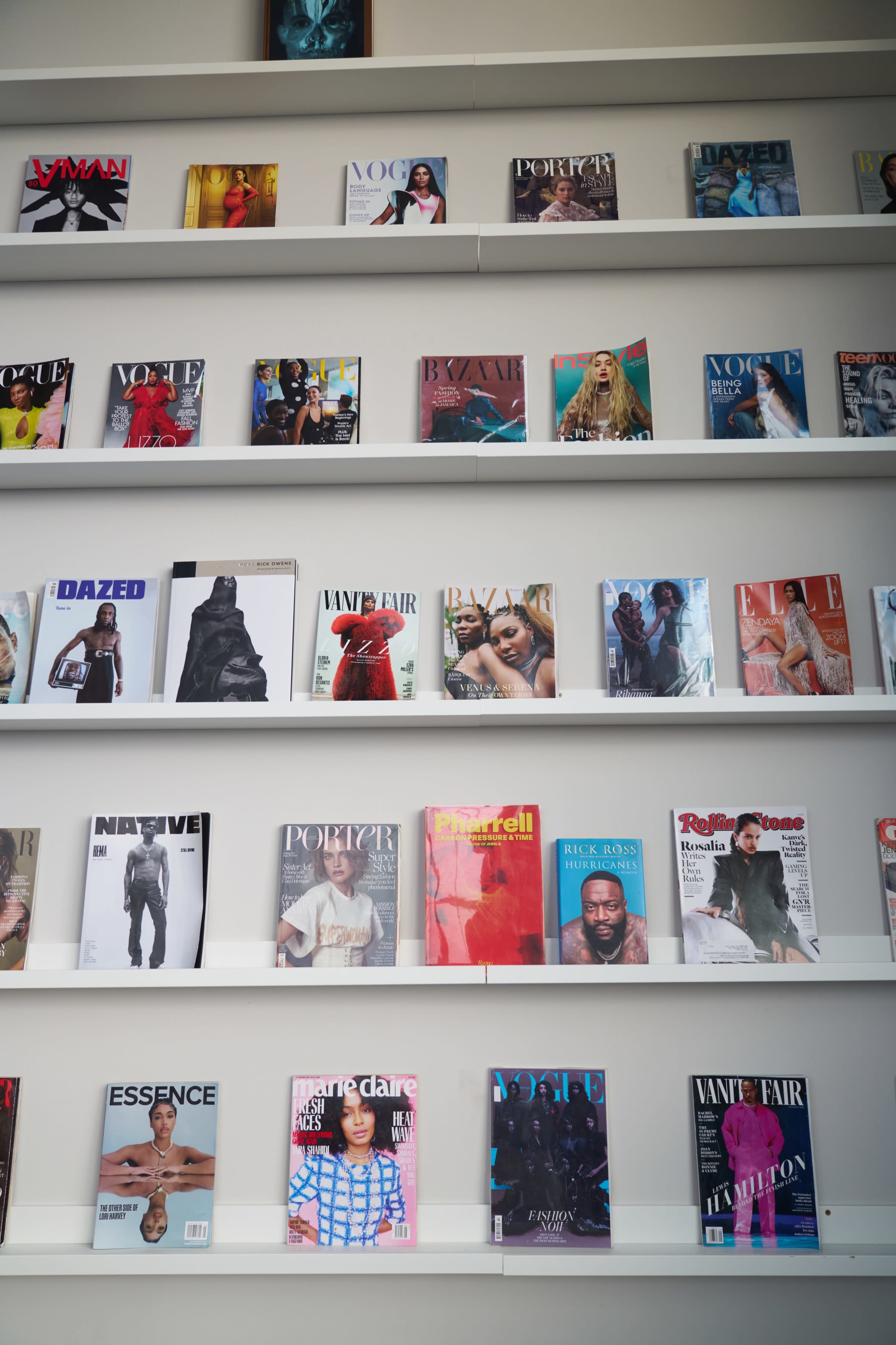 A display of various fashion magazines arranged neatly on shelves.