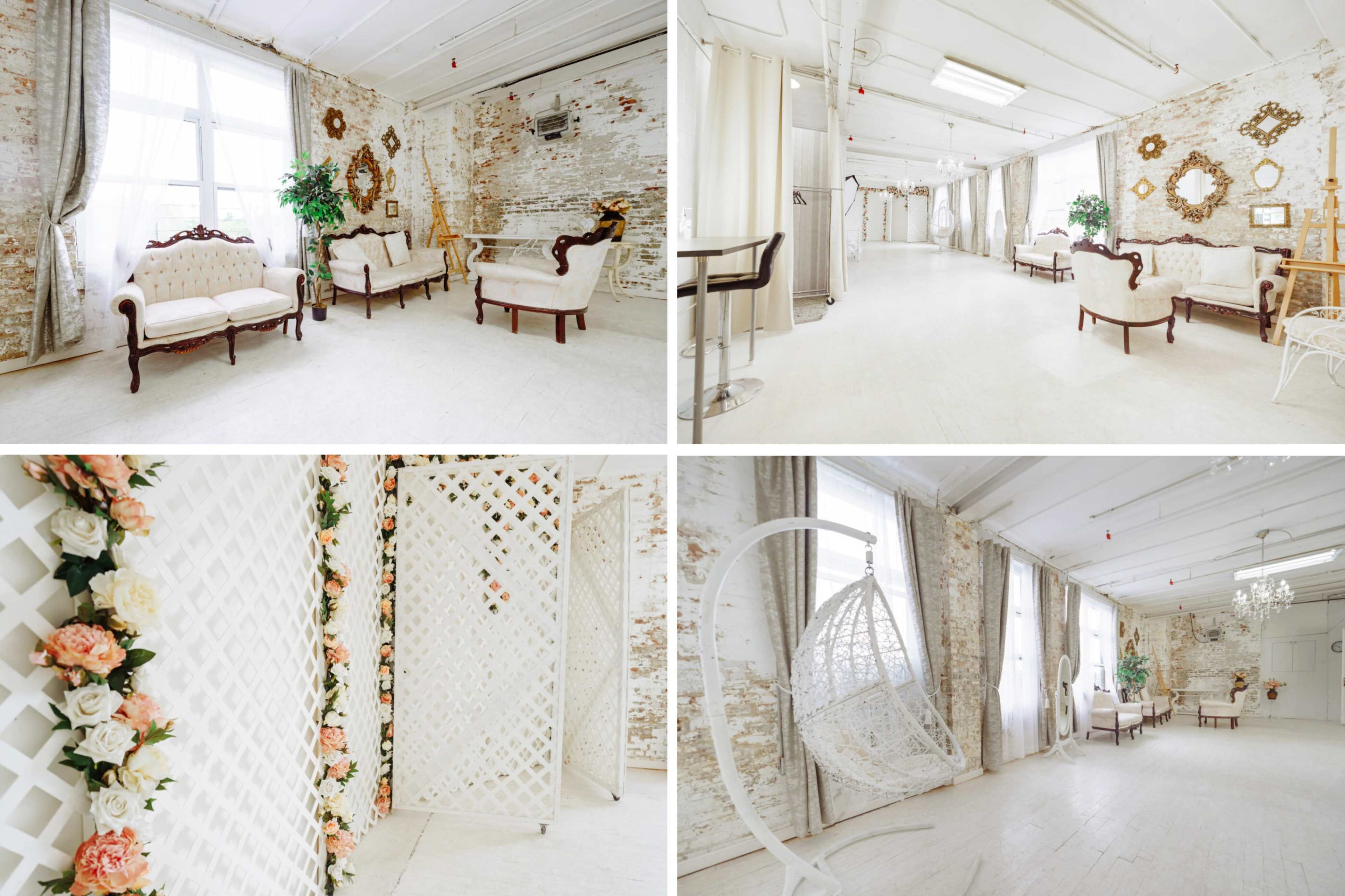 A bright, airy interior space featuring white walls, vintage furniture, decorative mirrors, and floral arrangements.