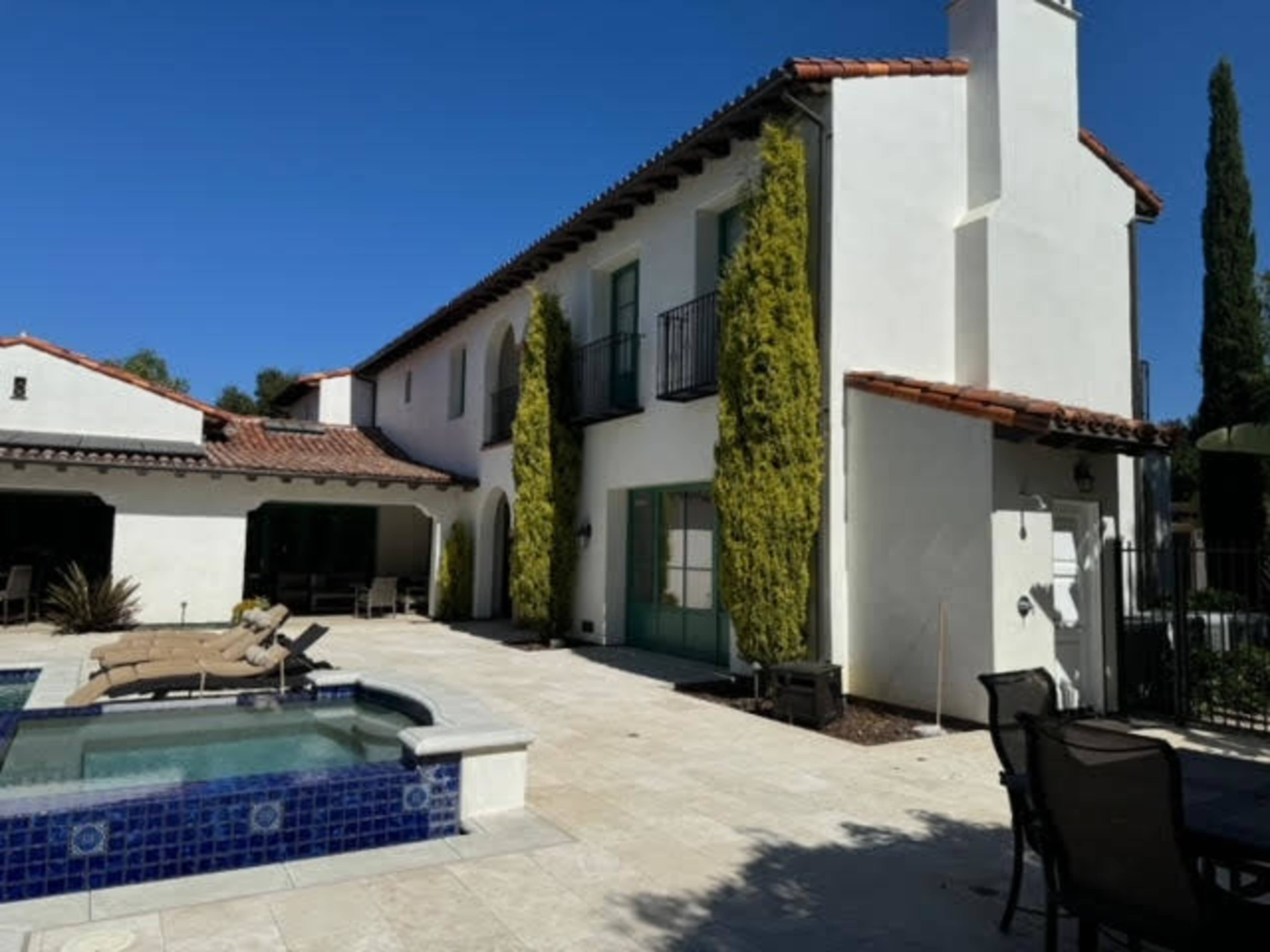 Mediterranean outdoor space with separate garden courtyard and backyard with a pool and spa.  It is surrounded by pal trees, olive trees, fruit trees, cypress trees.  Expansive and open back yard with endless views. Image in Turtle Rock, IRVINE, CA