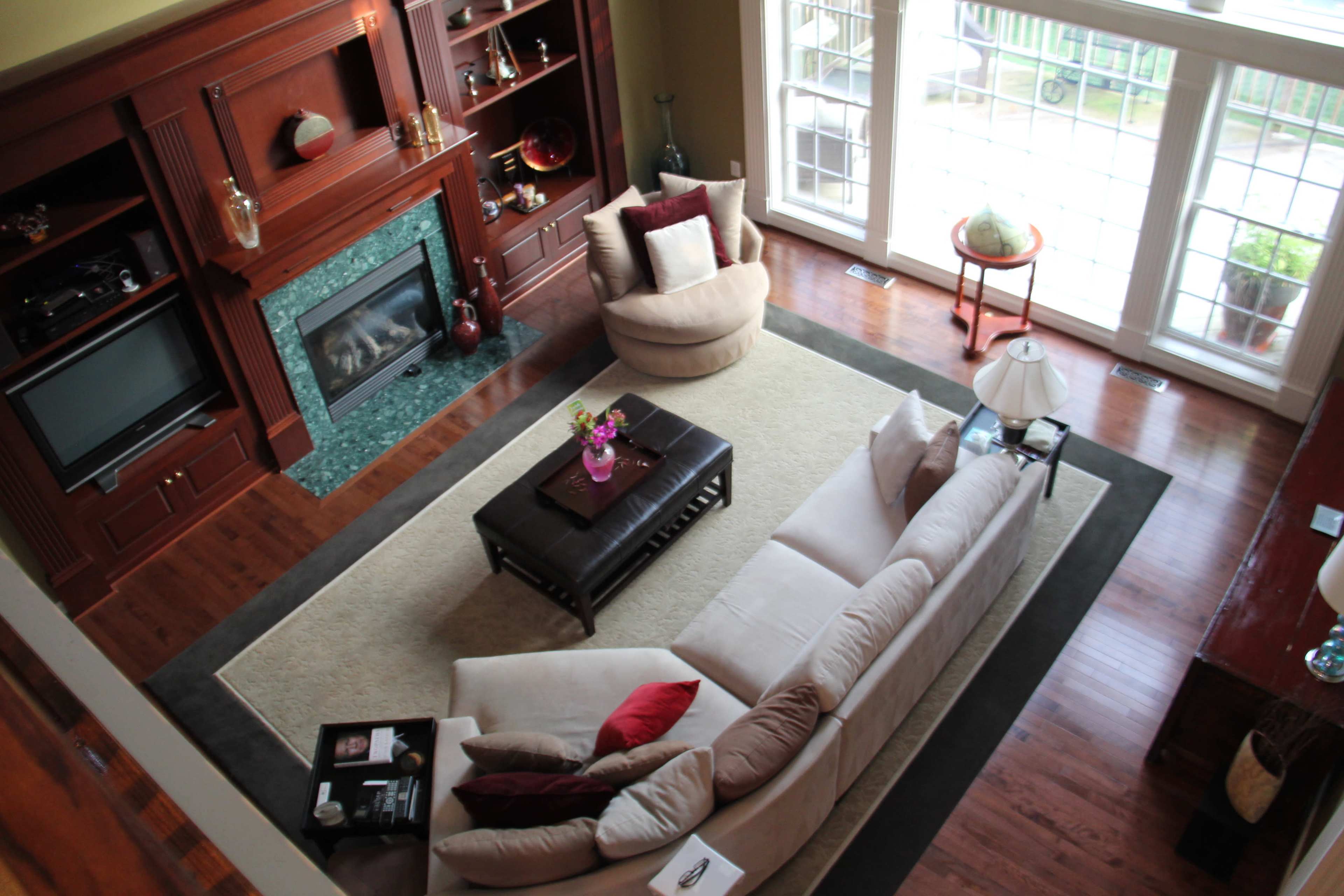 A spacious living room with a large beige sectional sofa, a coffee table, and a fireplace surrounded by built-in shelves.