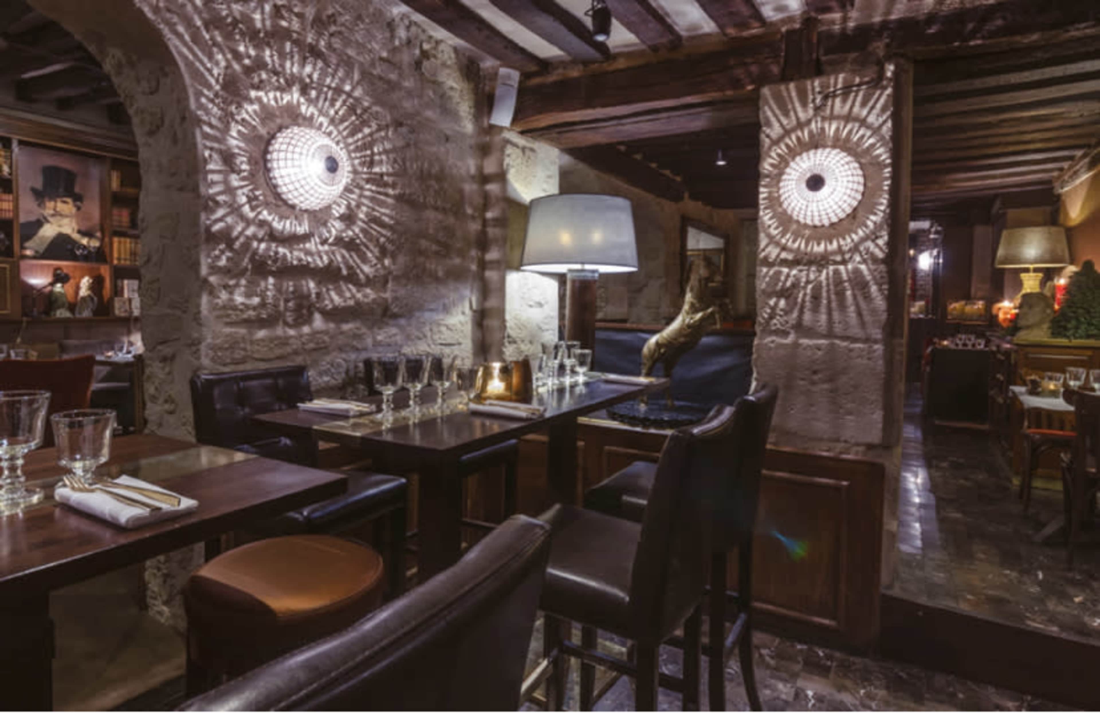 An elegant restaurant interior with wooden beams, stone walls, and ambient lighting highlighting the seating area.
