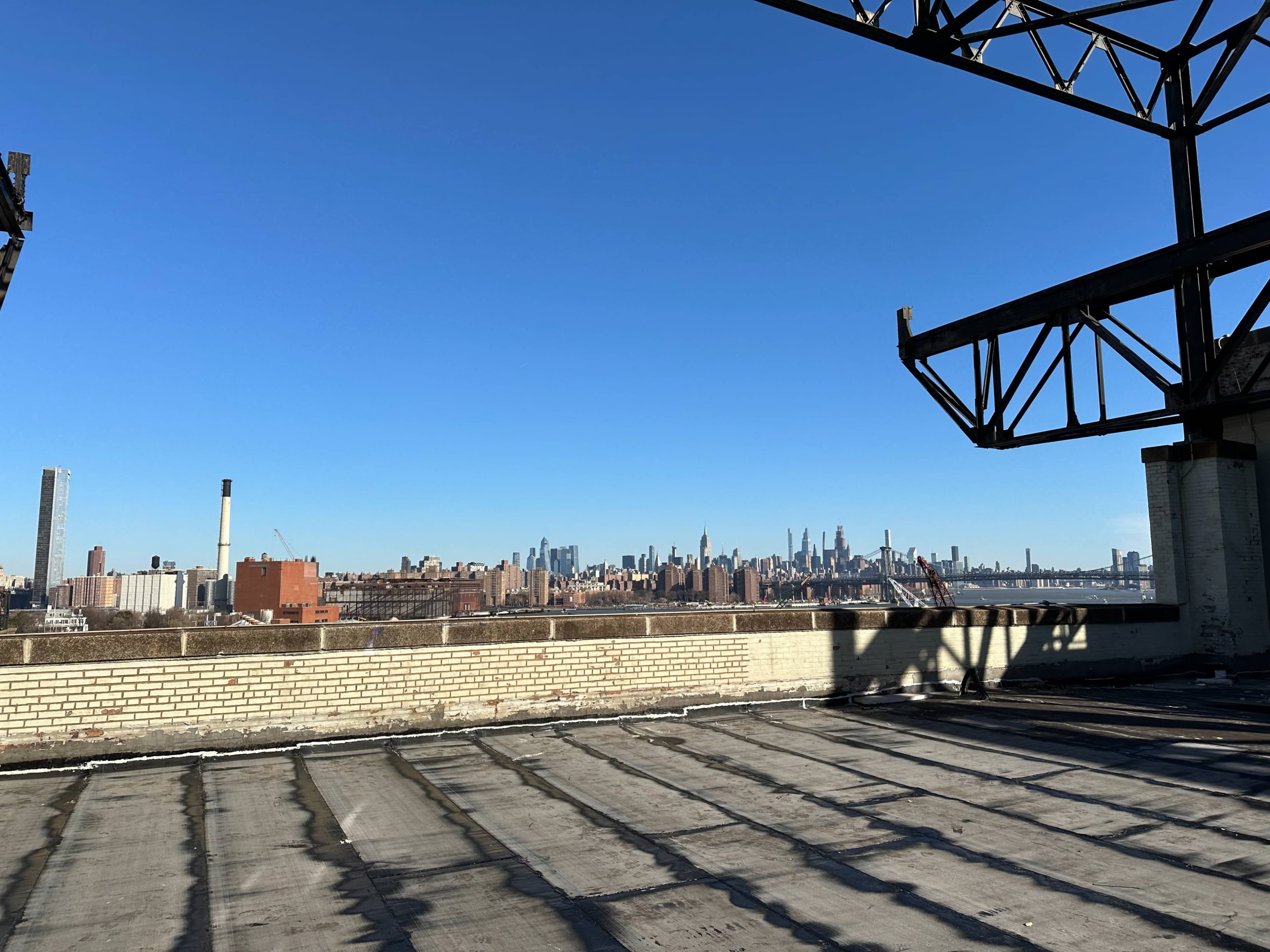 A rooftop view of a city skyline under a clear blue sky.