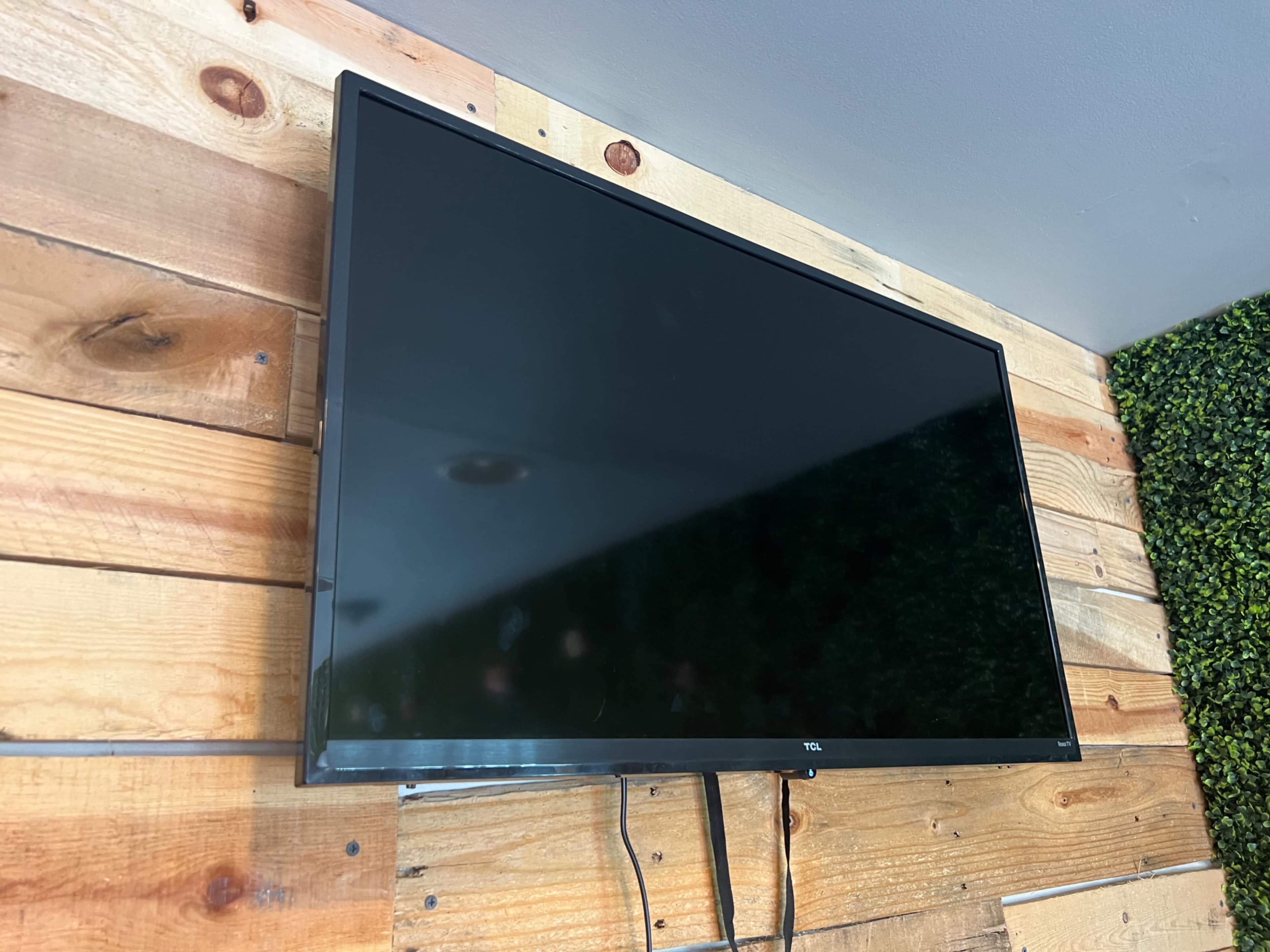 A flat-screen television is mounted on a wooden wall.