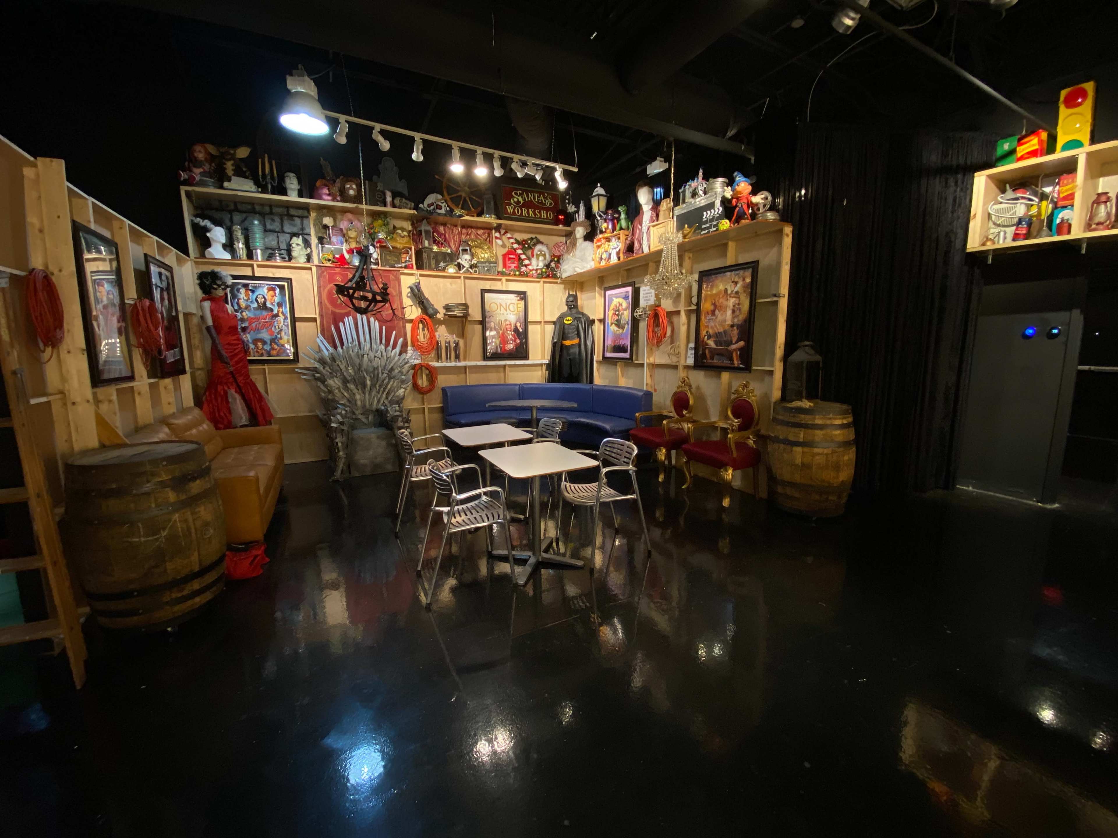 The scene features a themed lounge area with a mix of seating, decorative items, and entertainment memorabilia displayed on the walls.