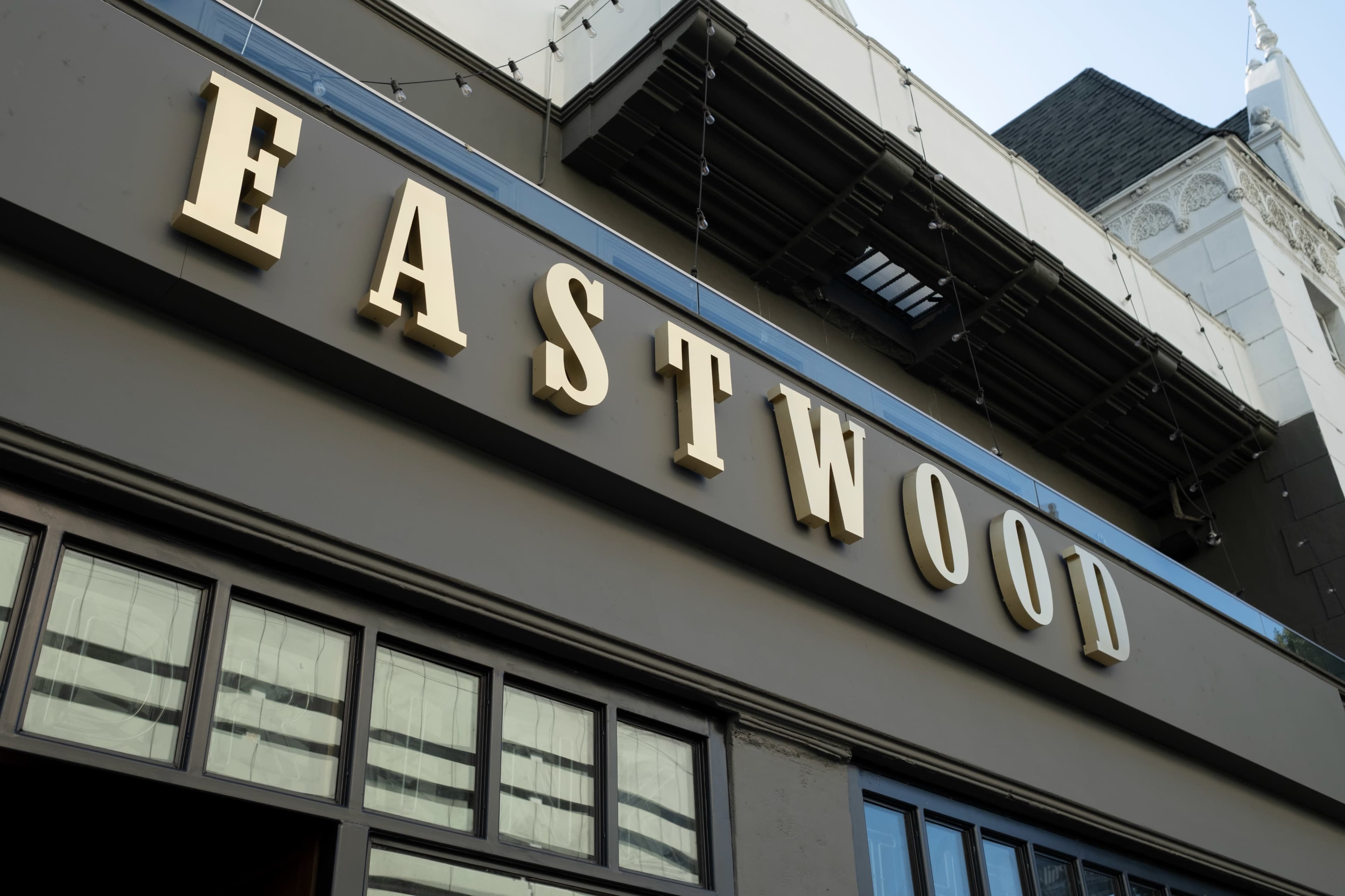 The image shows the sign reading "EASTWOOD" on the façade of a building.