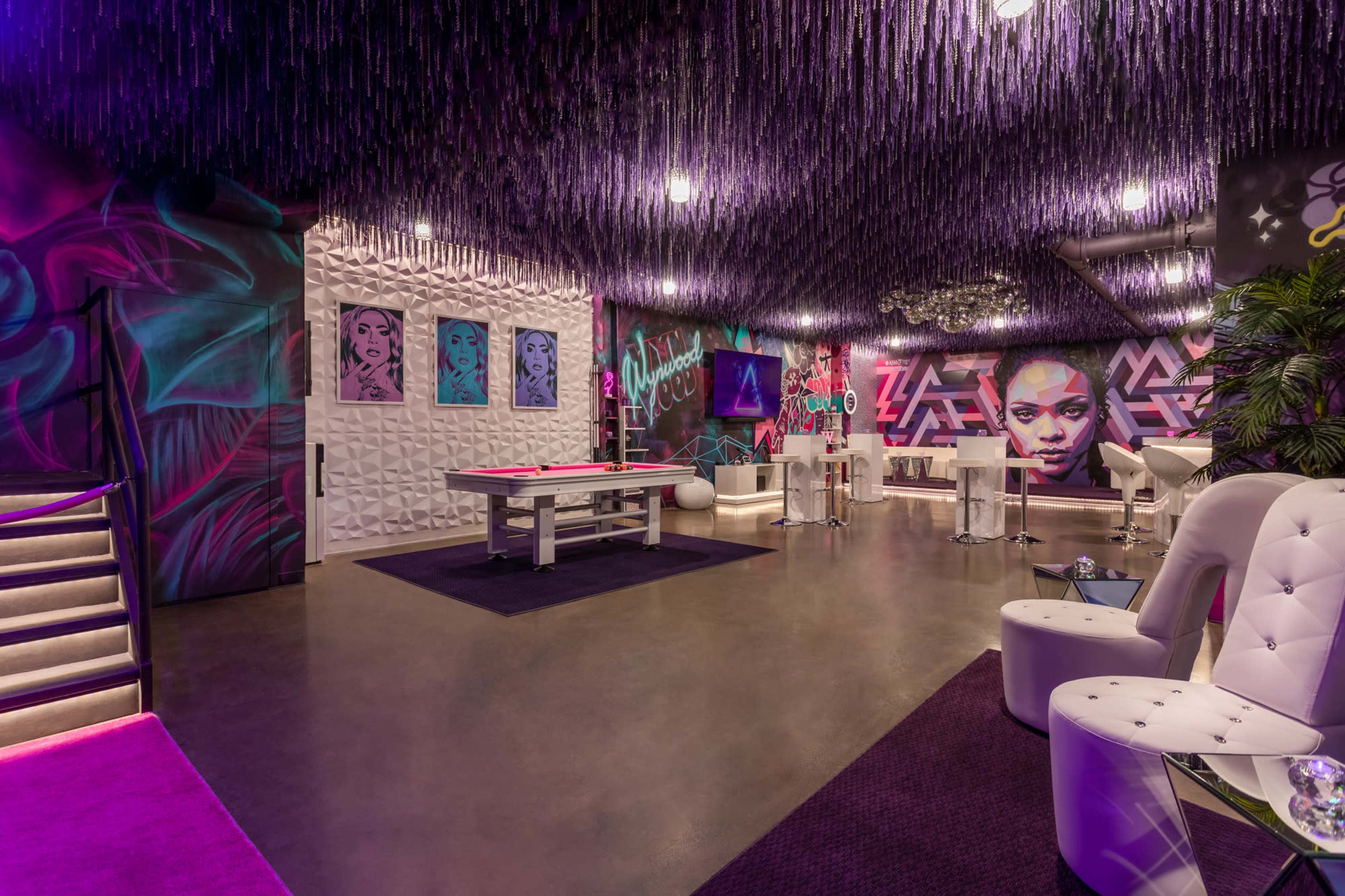 A vibrant interior space featuring colorful wall art, modern furniture, and decorative lighting.
