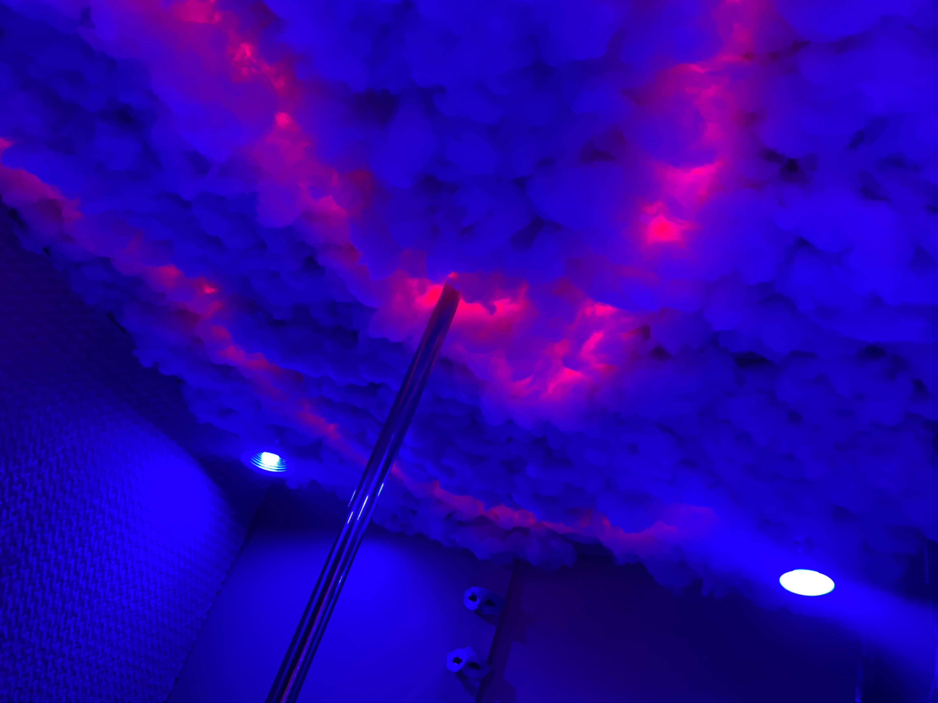 The image shows a ceiling adorned with textured white material illuminated by blue and red lights.