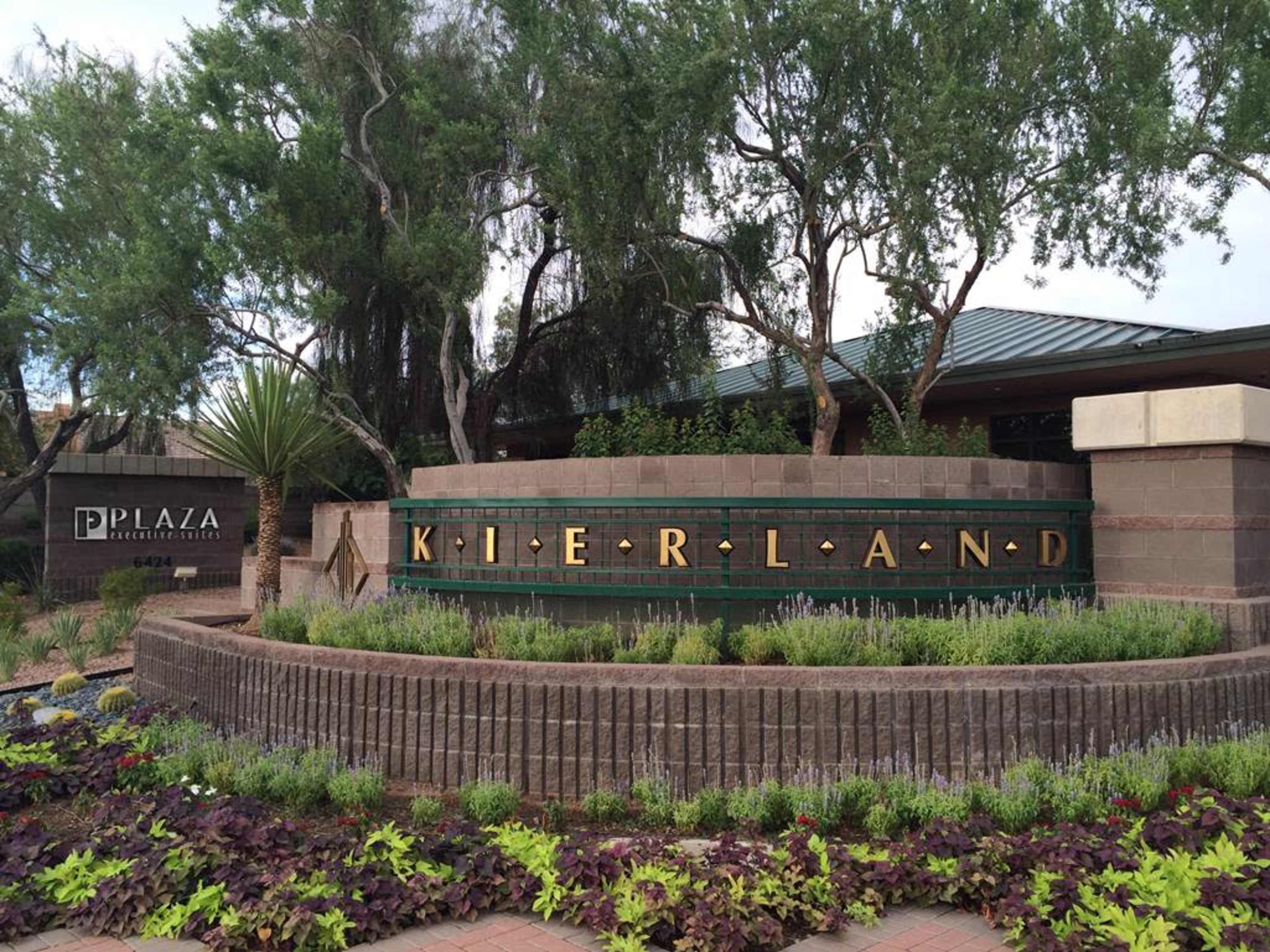 A landscaped entrance sign for Kierland, surrounded by greenery and flowering plants.