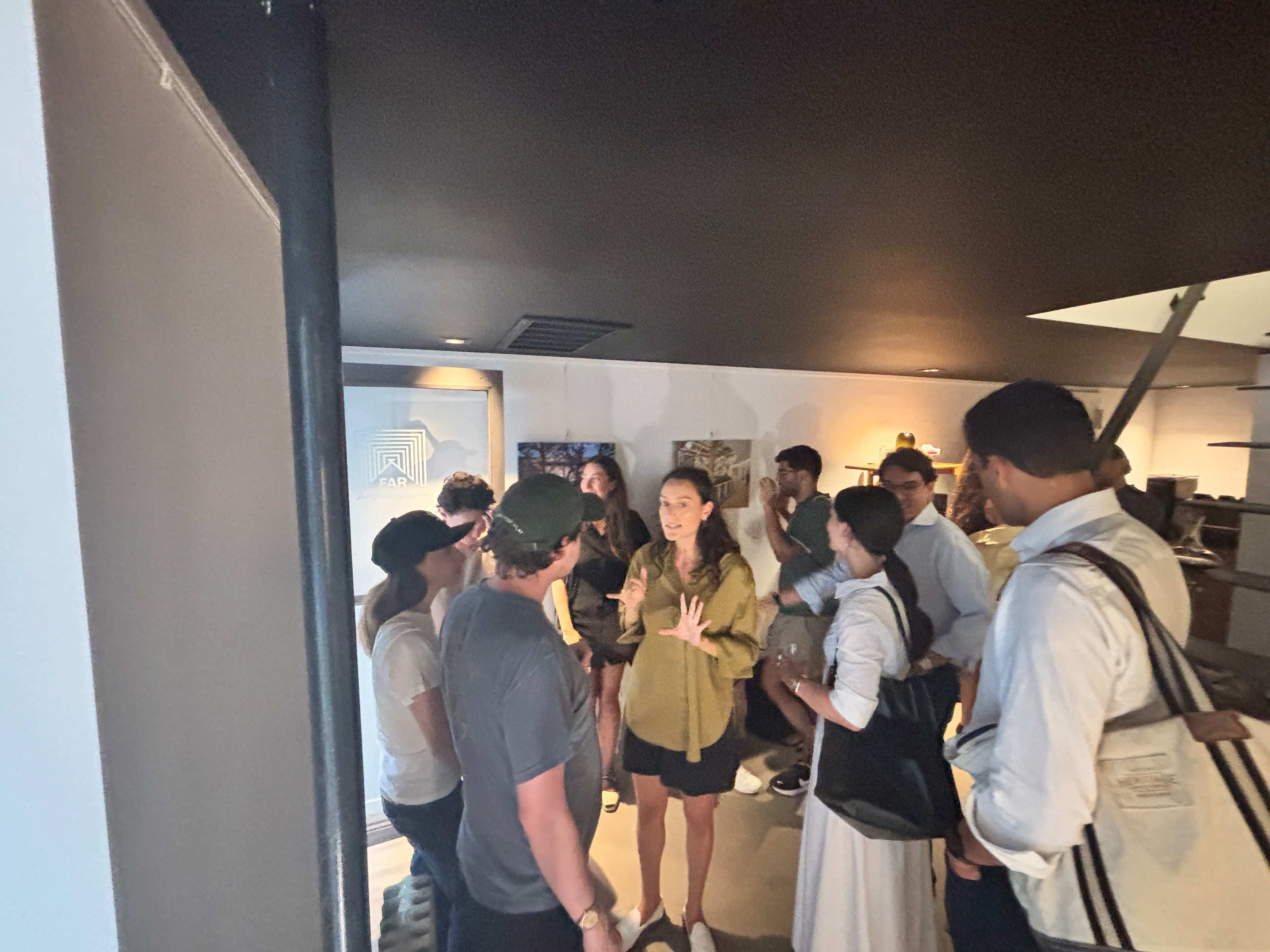 A group of people engages in conversation in a well-lit indoor setting.