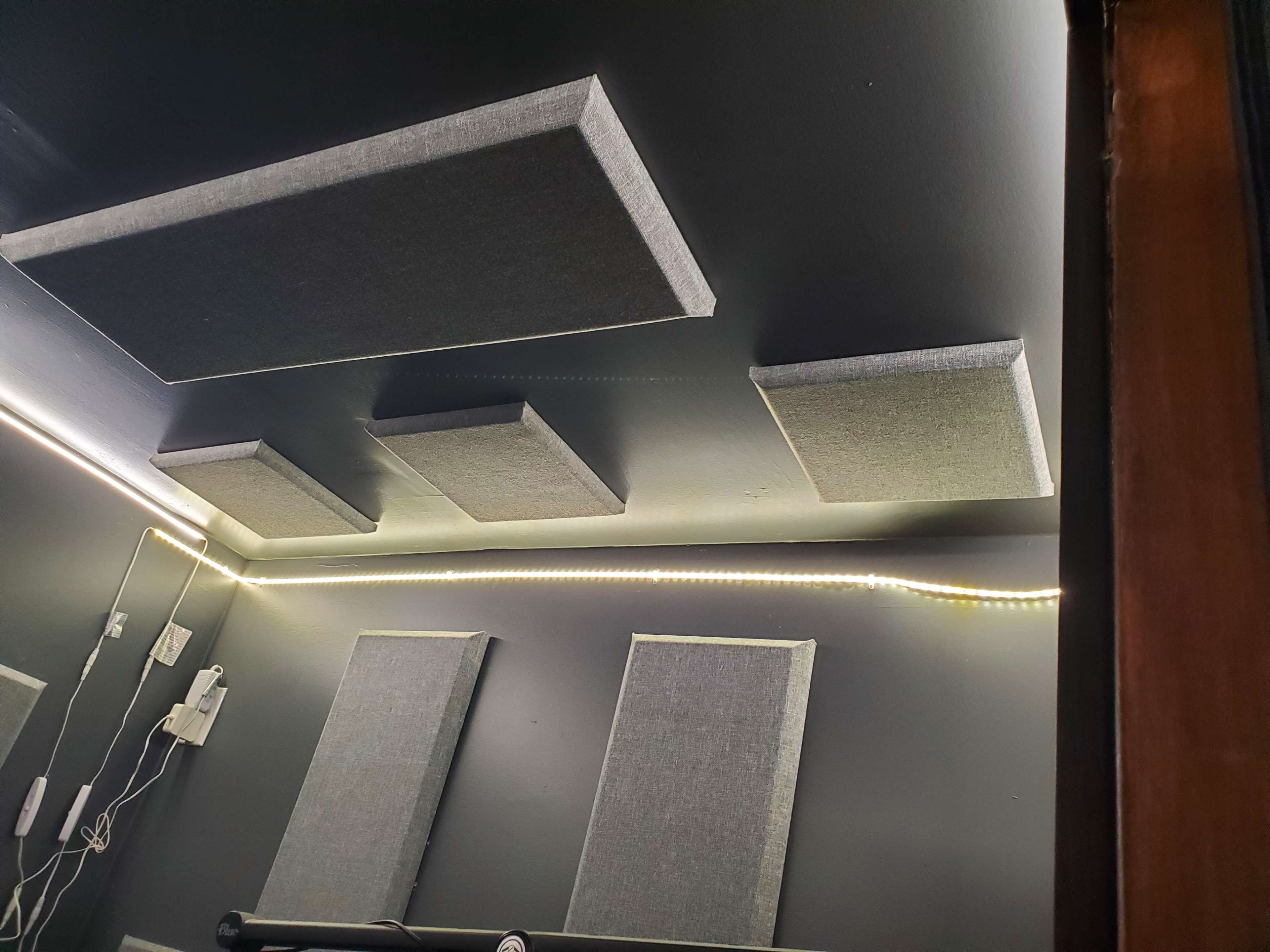 A room with soundproofing panels mounted on the walls and ceiling, along with ambient lighting along the edges.