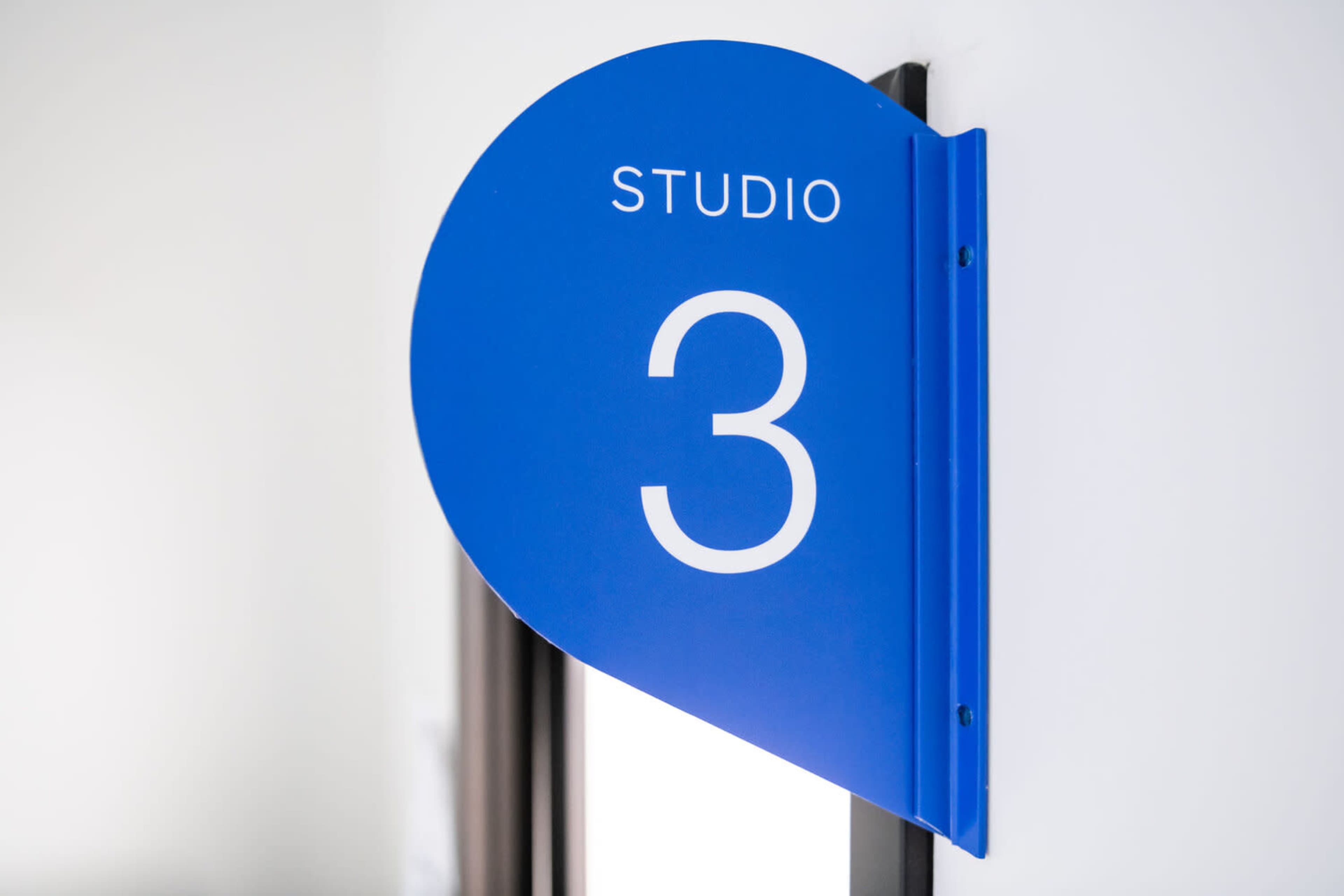 A blue sign displaying the text "STUDIO 3" is mounted on a wall.