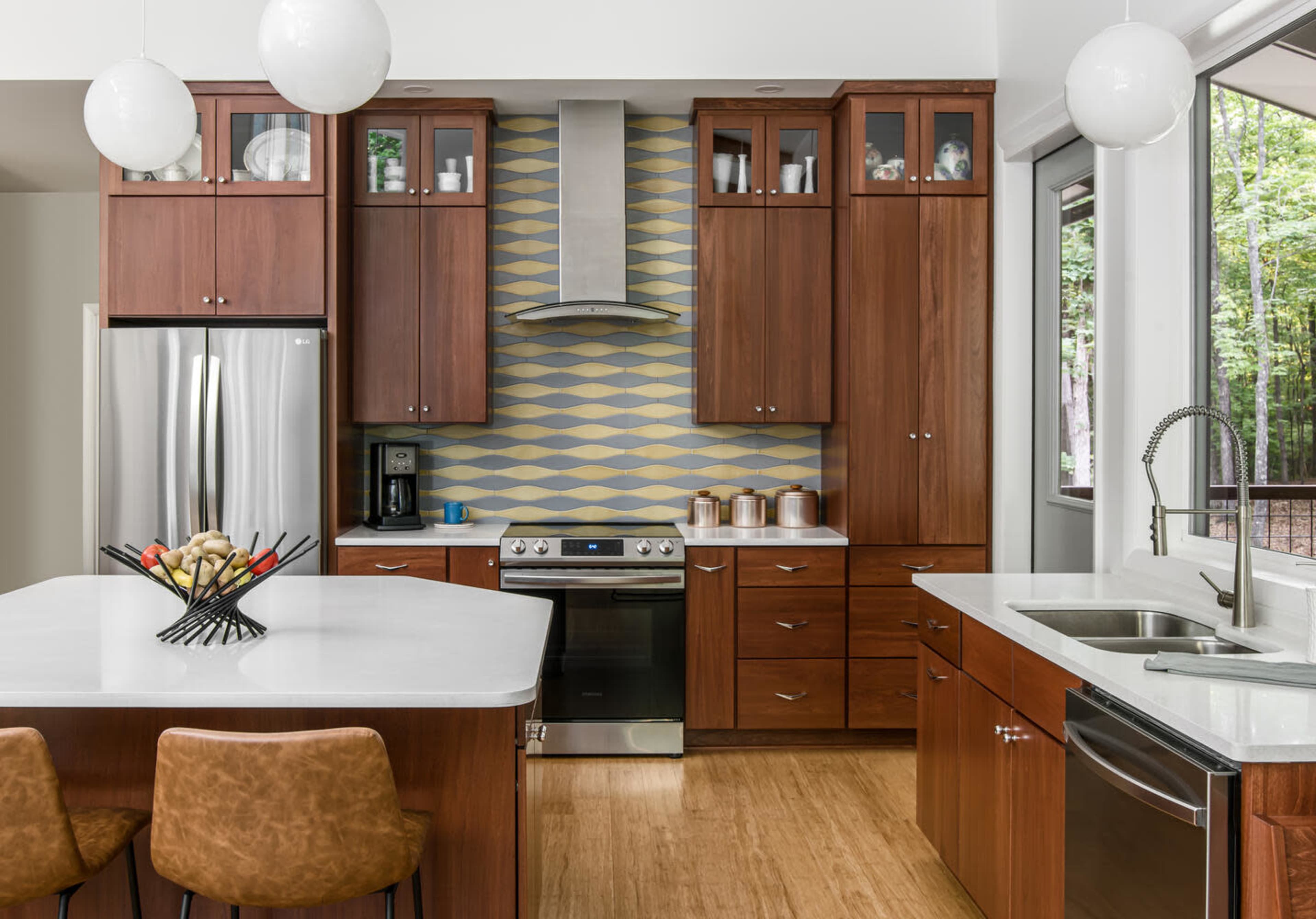 The kitchen features dark wood cabinetry, a stainless steel oven, and a patterned backsplash behind the countertop.
