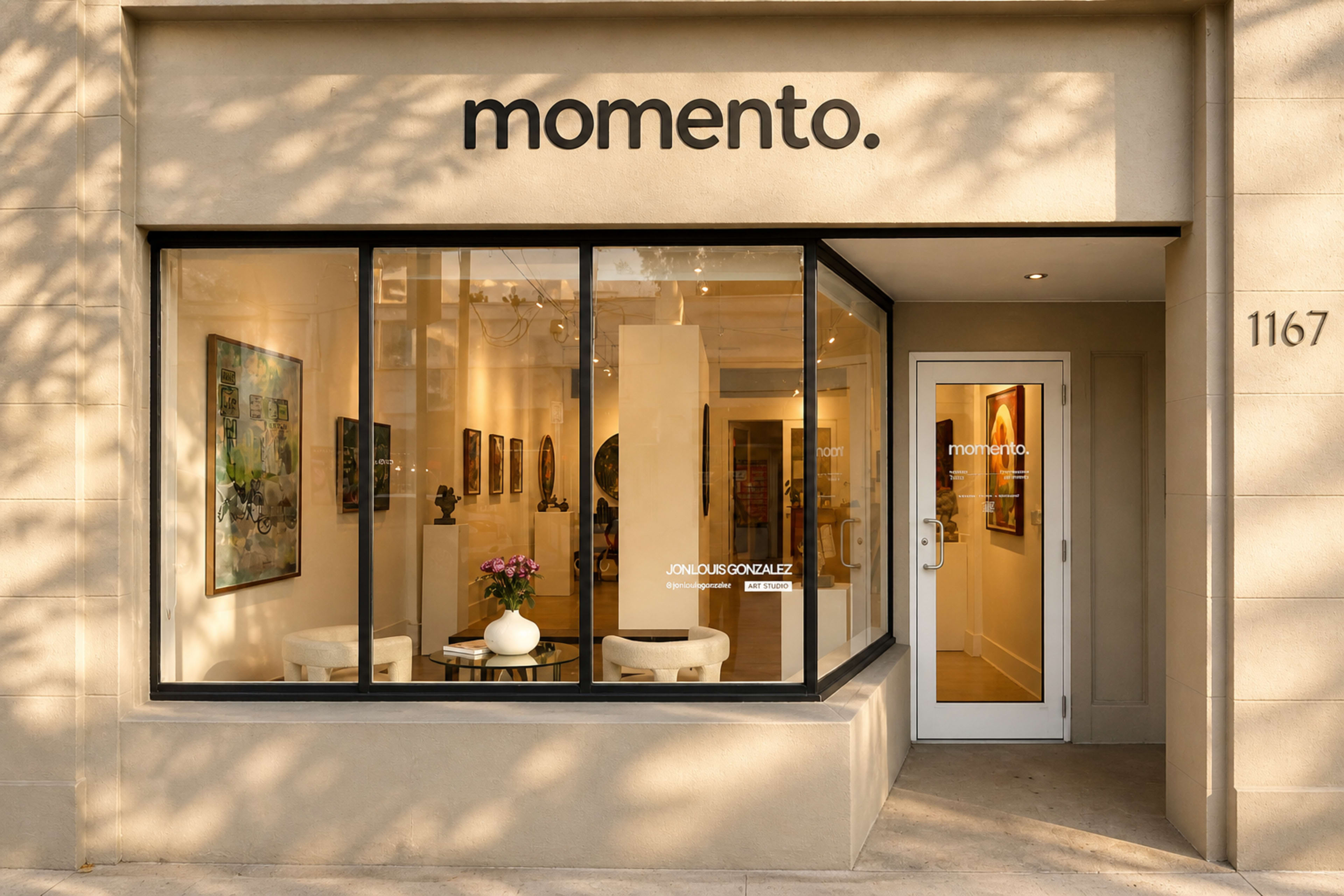 The image shows the exterior of a gallery named "momento" featuring a glass storefront with seating and artwork visible inside.