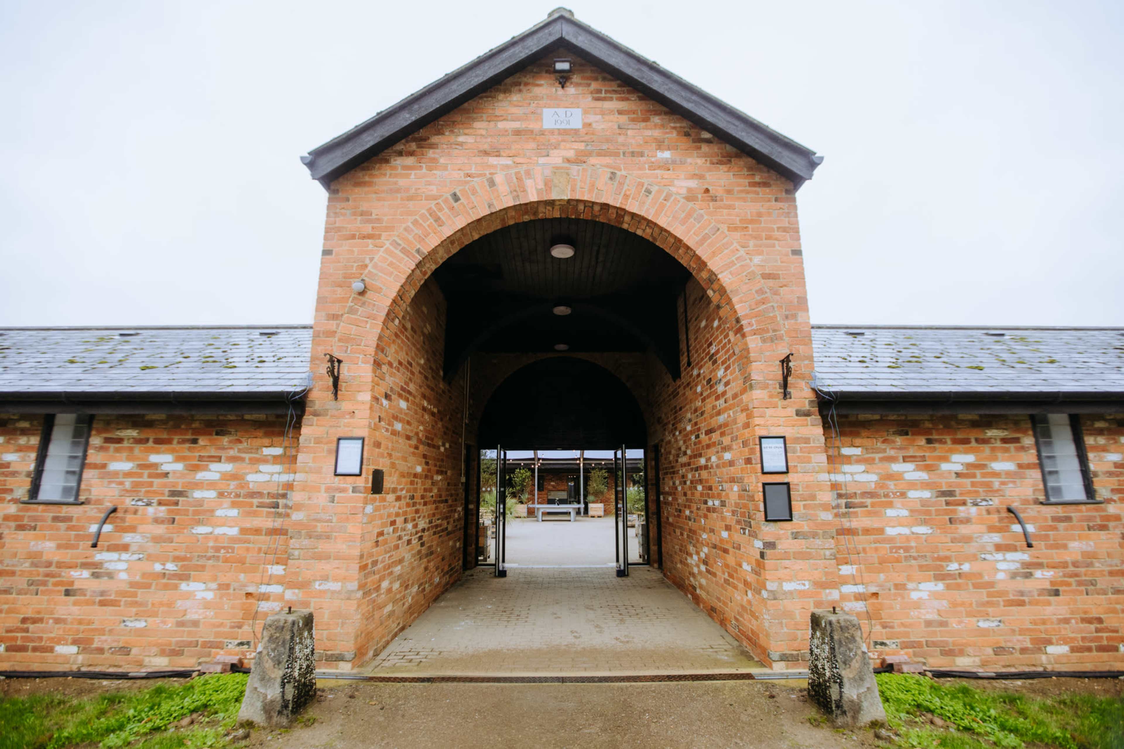 A brick building with a large arched entrance and a tiled roof.
