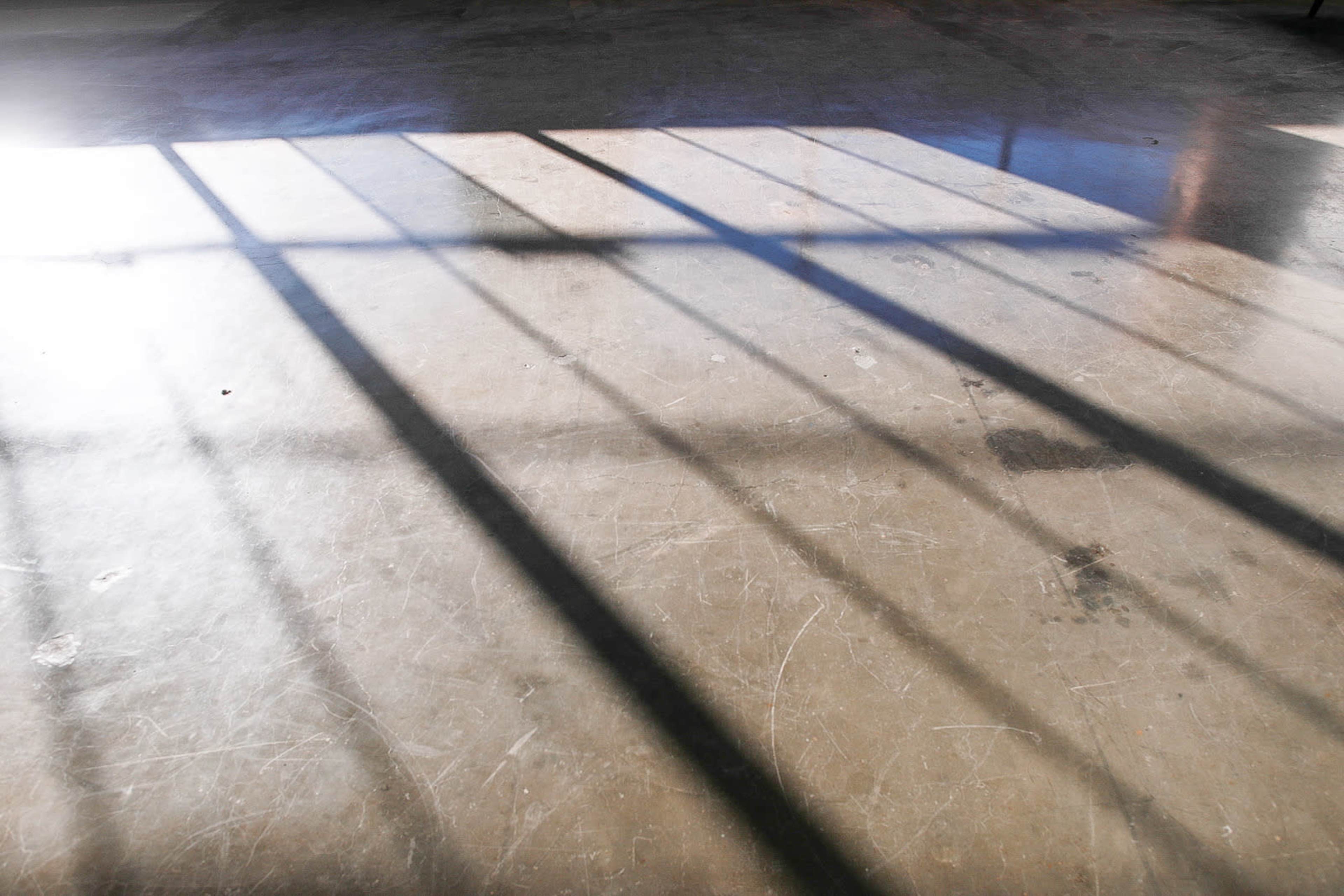 Sunlight casts long shadows across a polished concrete floor.