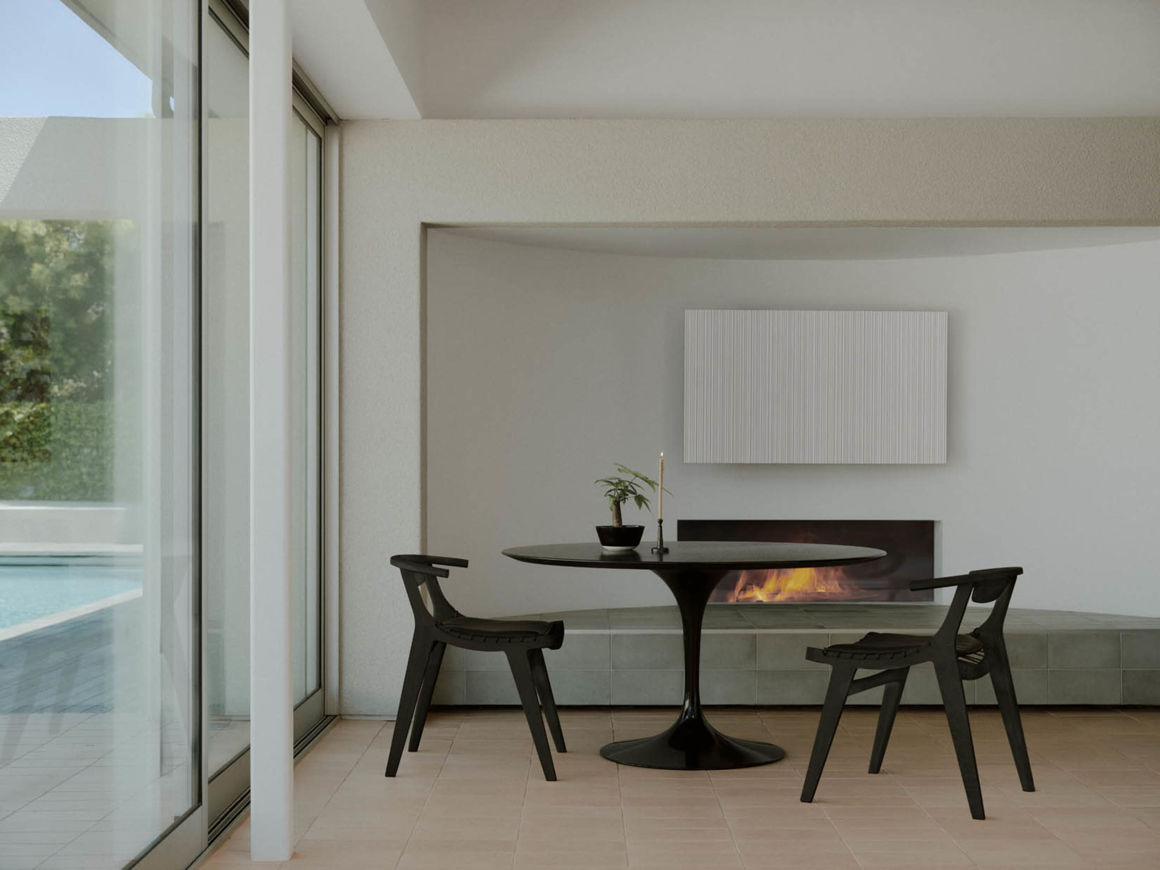 The image shows a modern dining area with a round black table, two chairs, and a fireplace, adjacent to large glass windows overlooking a pool.