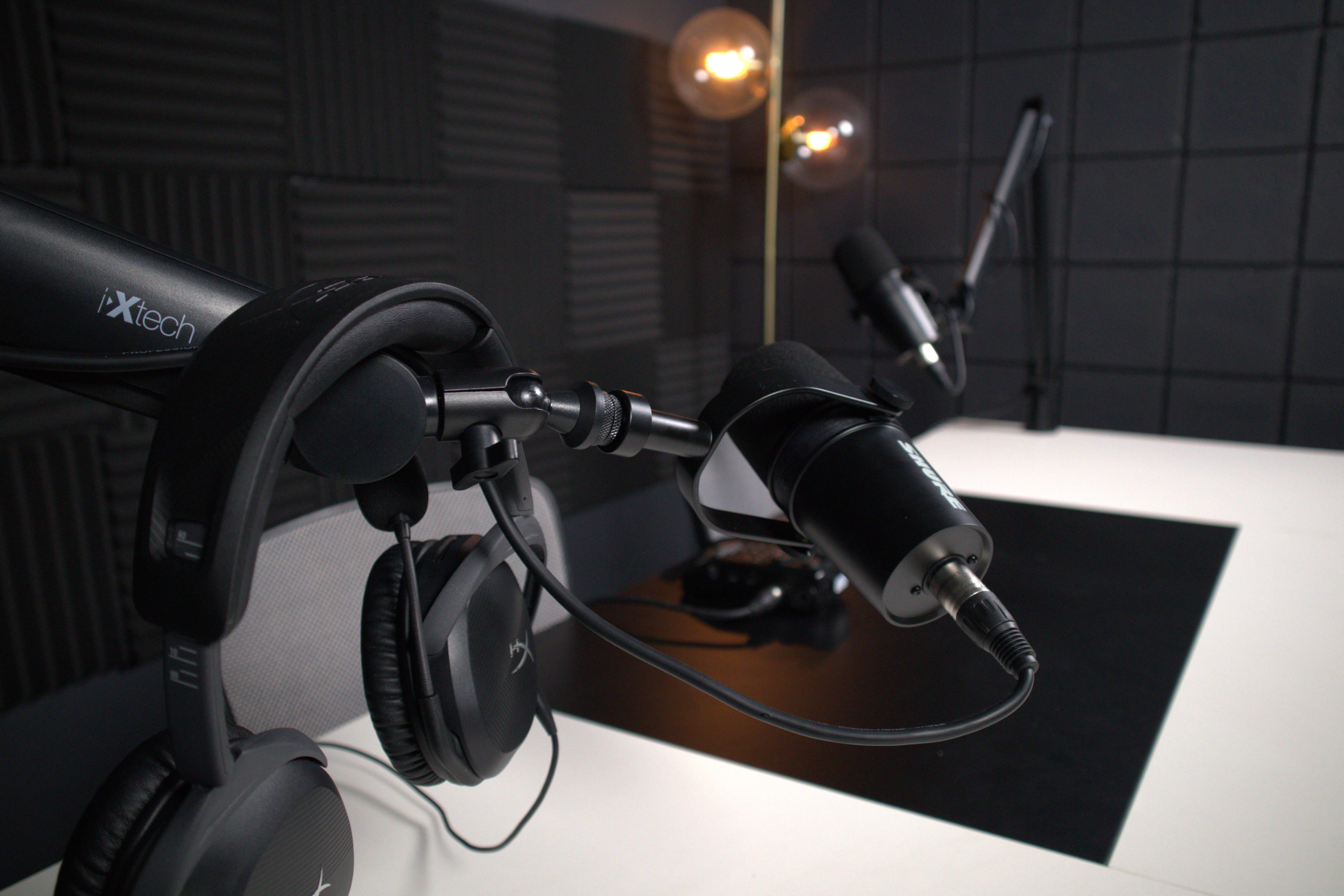 A close-up of a microphone and headphones on a broadcast equipment setup in a recording studio.