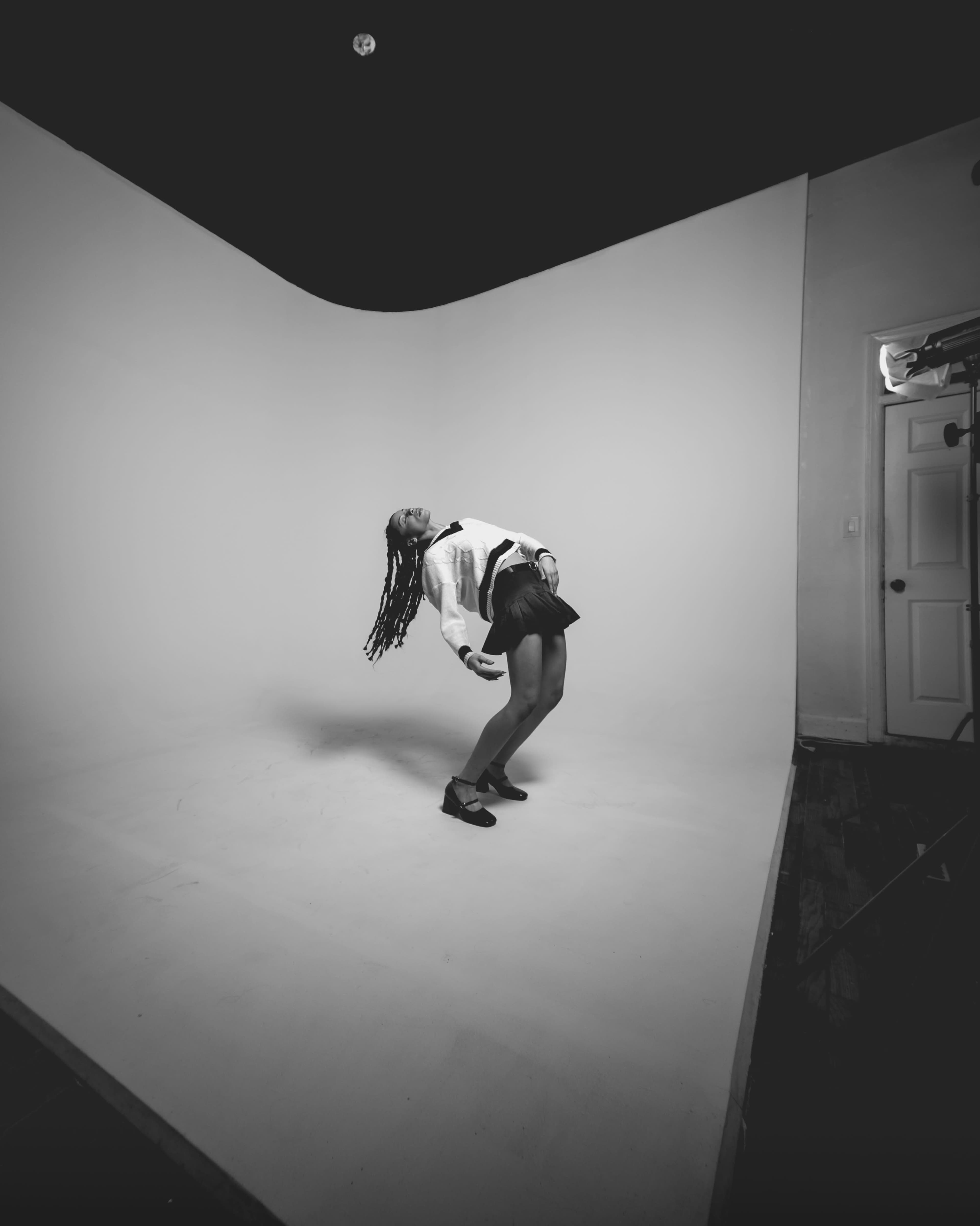A person is performing a dance move against a plain white backdrop.