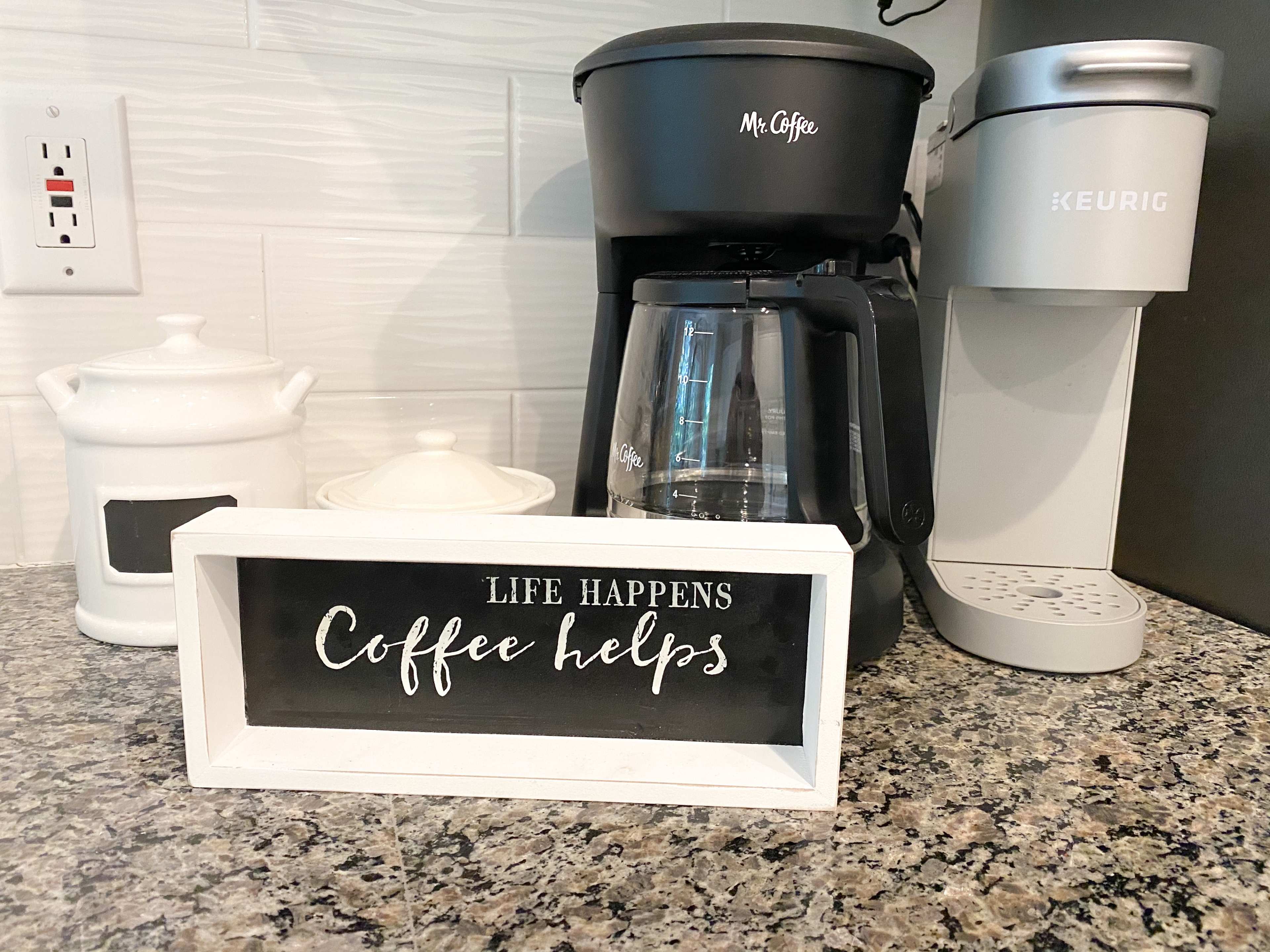 A coffee station displays a coffee maker, a Keurig machine, and a decorative sign that reads "LIFE HAPPENS Coffee helps."