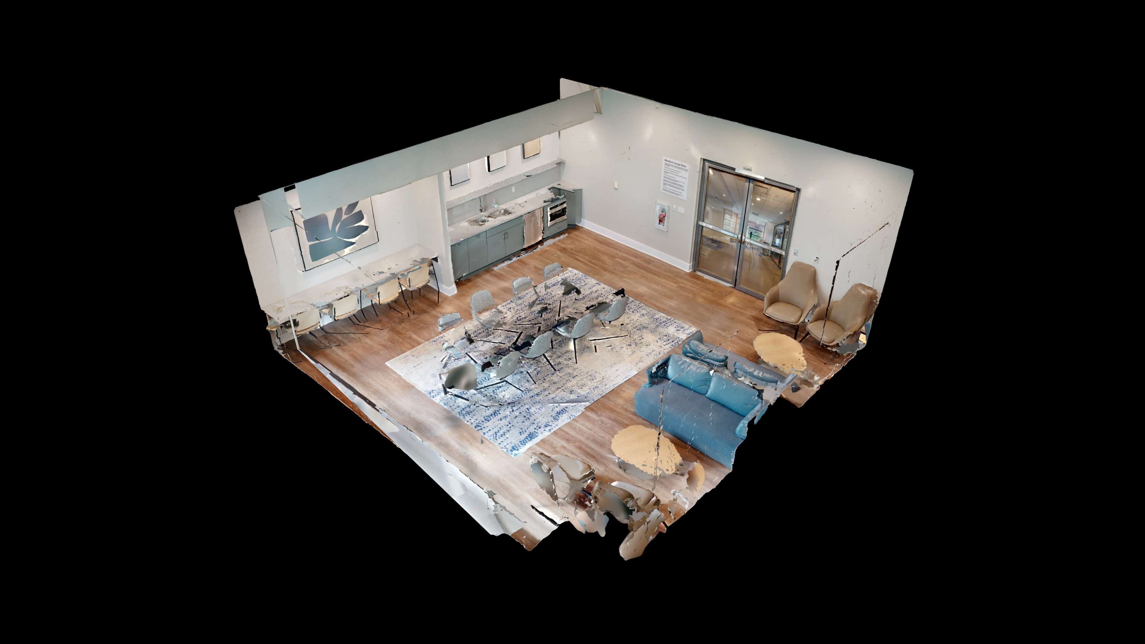 The image shows a spacious modern room featuring a kitchen area, a dining table, and a living area with a blue couch and seating.