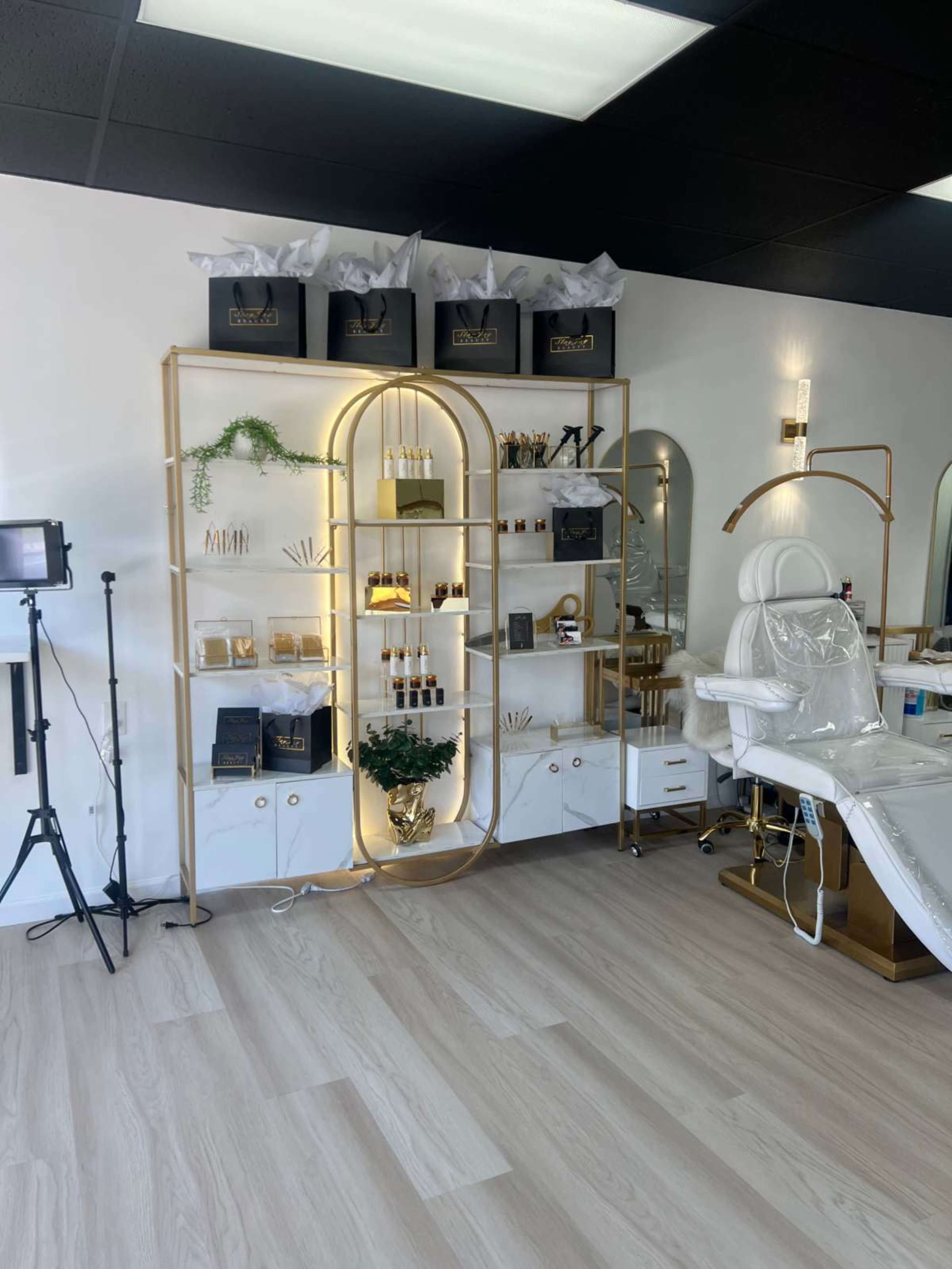A modern beauty salon interior with a display shelf, treatment chair, and neatly organized products.