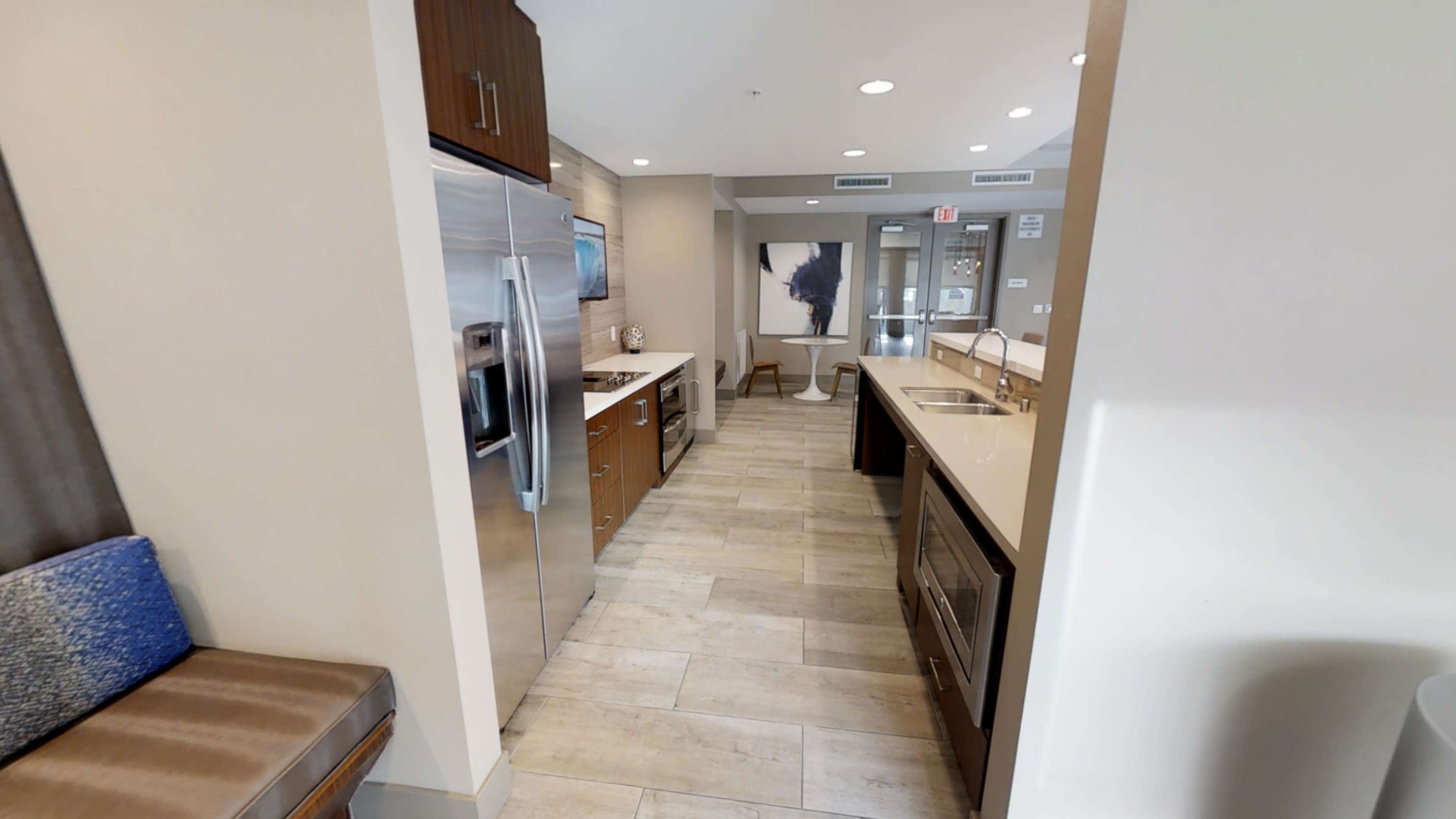 A modern kitchen with stainless steel appliances, light-colored countertops, and a spacious layout.