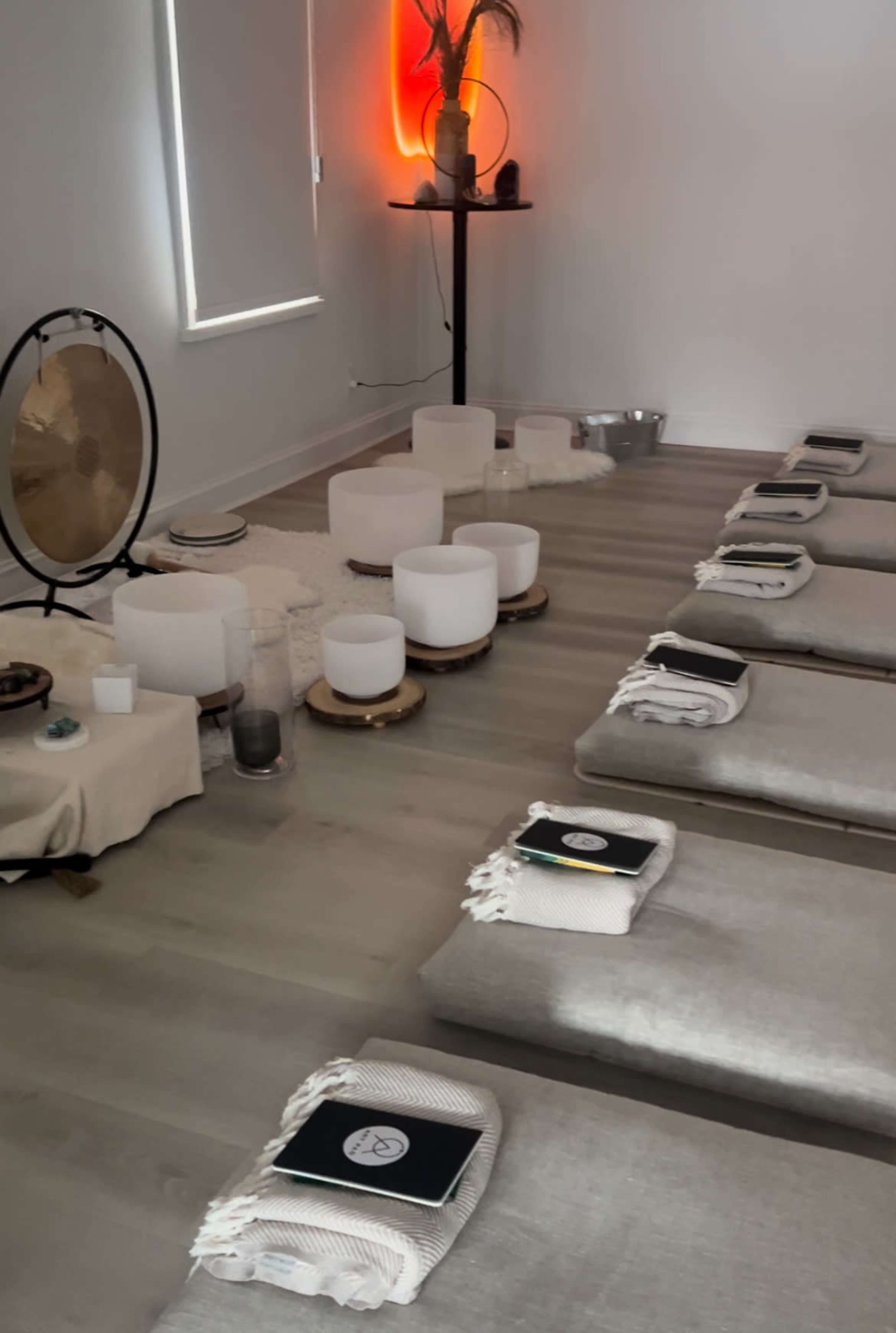 A tranquil meditation space with mats arranged neatly on the floor, surrounded by various calming decor elements and soft lighting.