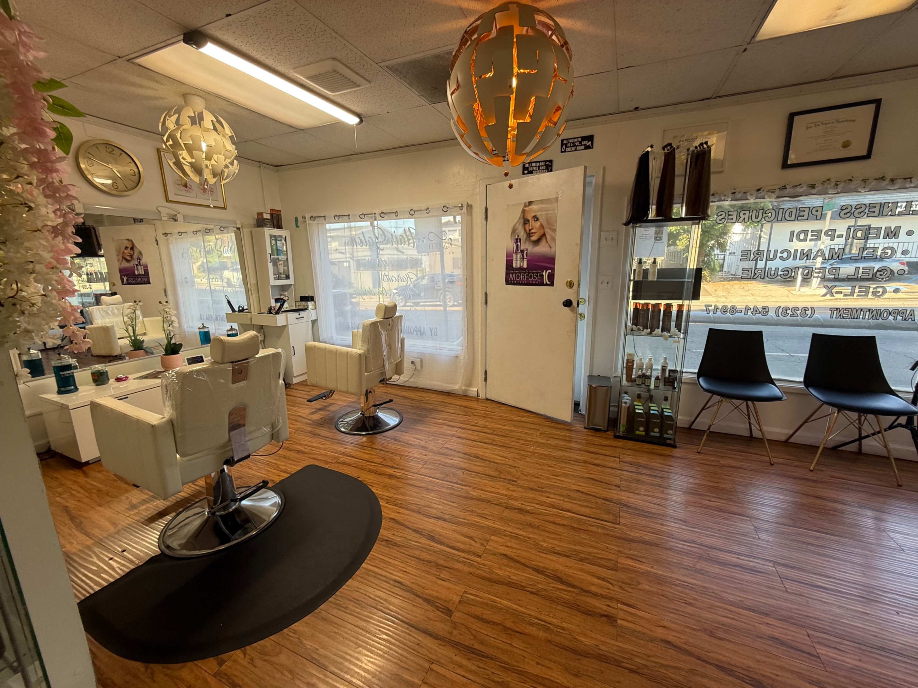 The image shows the interior of a salon with styling chairs, decorative lighting, and products displayed on shelves.