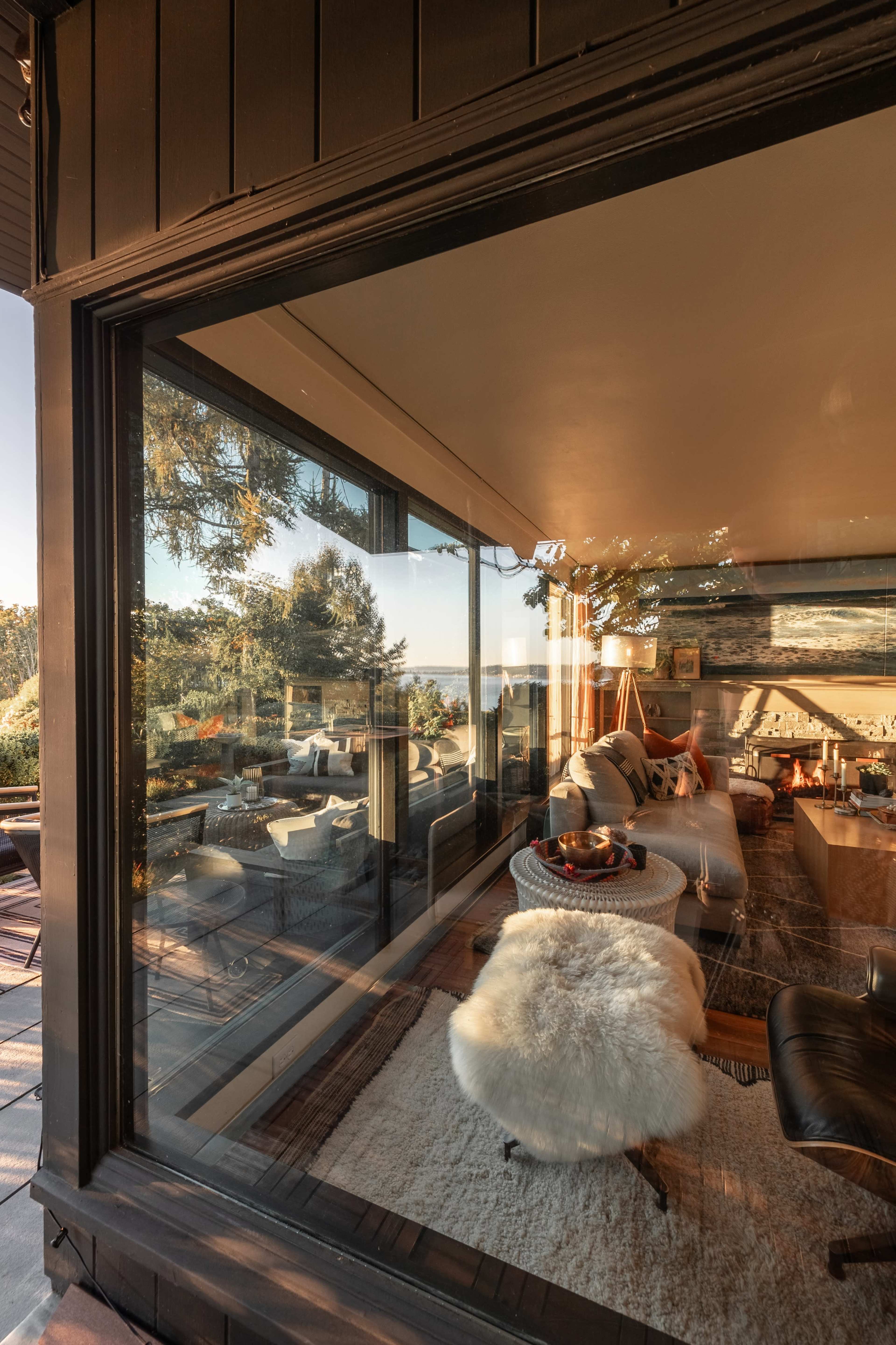 A modern living room with large windows overlooking a scenic outdoor area.