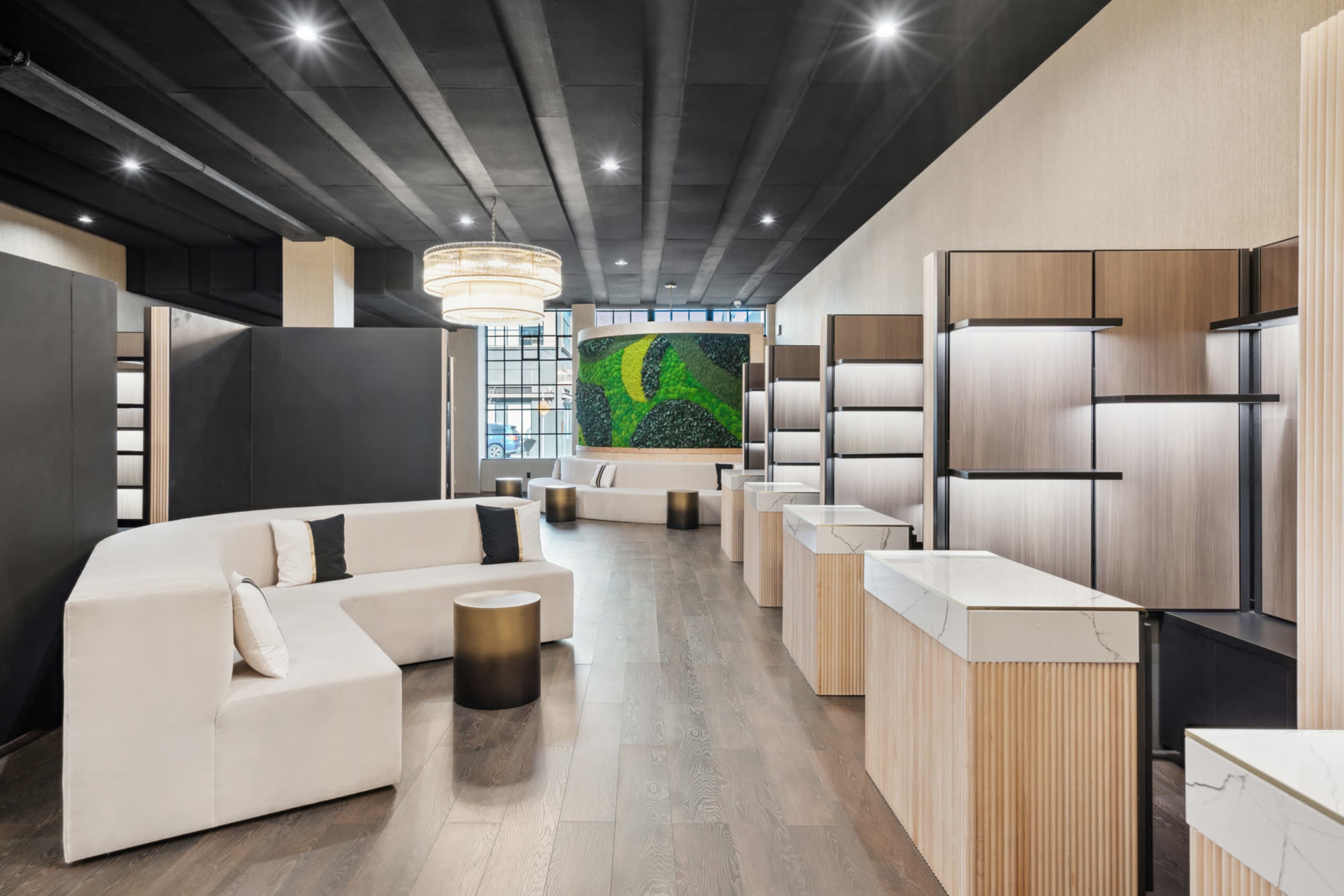 The image shows a modern interior design of a retail space featuring a combination of curved seating, display shelves, and a green wall accent.