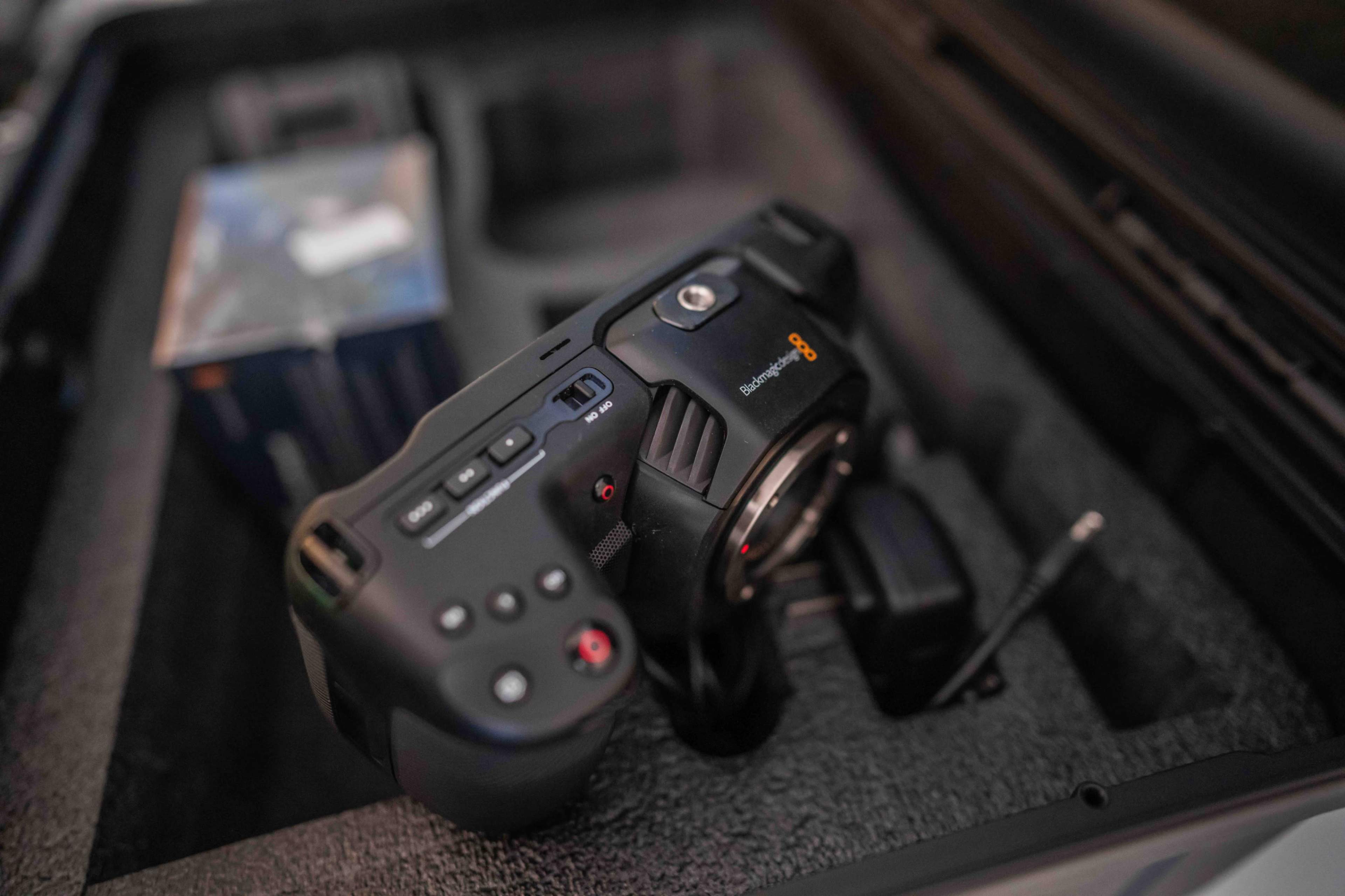 A Blackmagic camera is positioned inside a protective case, surrounded by foam padding and a small box in the background.