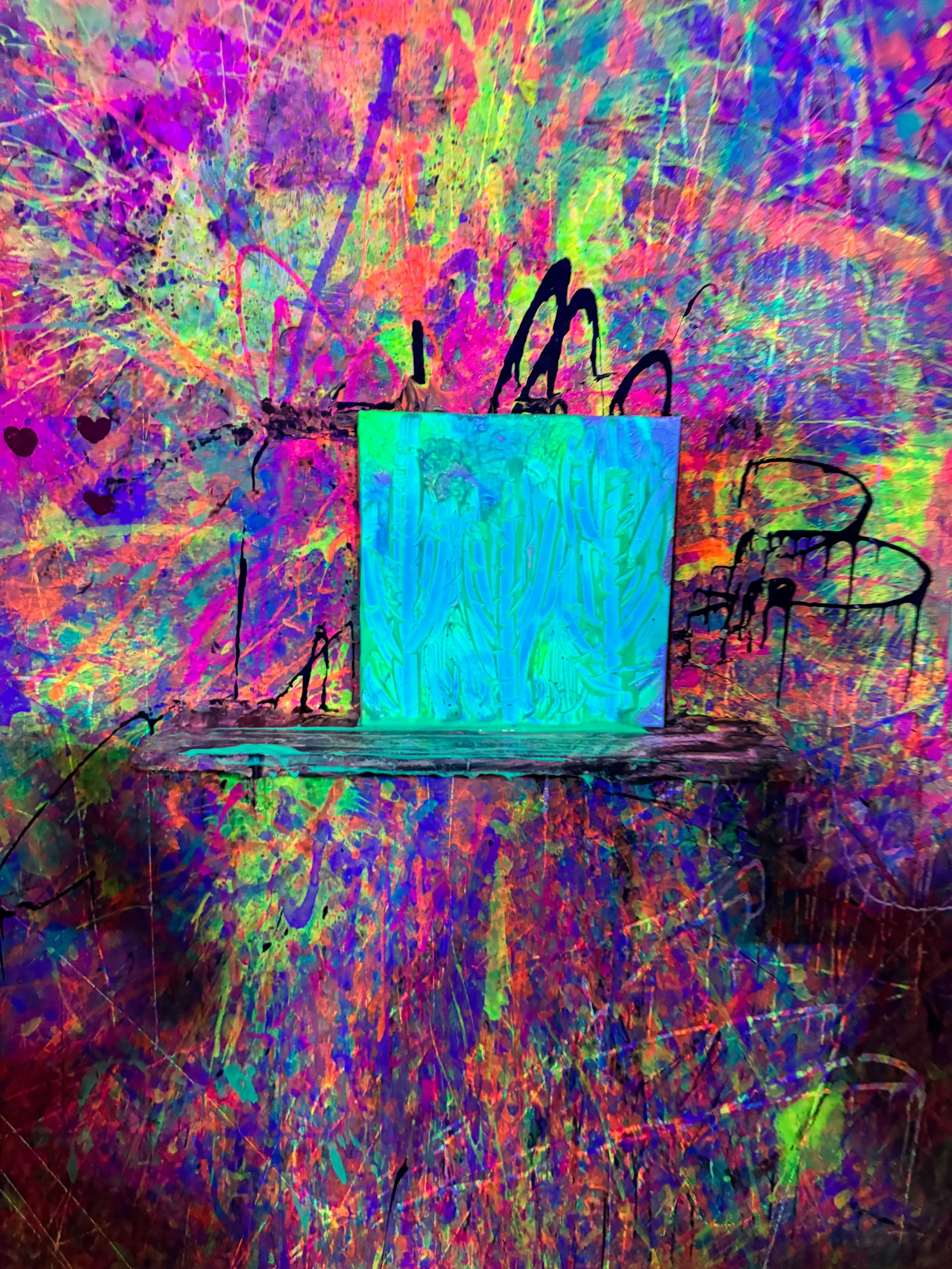 The image features a brightly colored abstract background with a central blue and green painting of cacti.