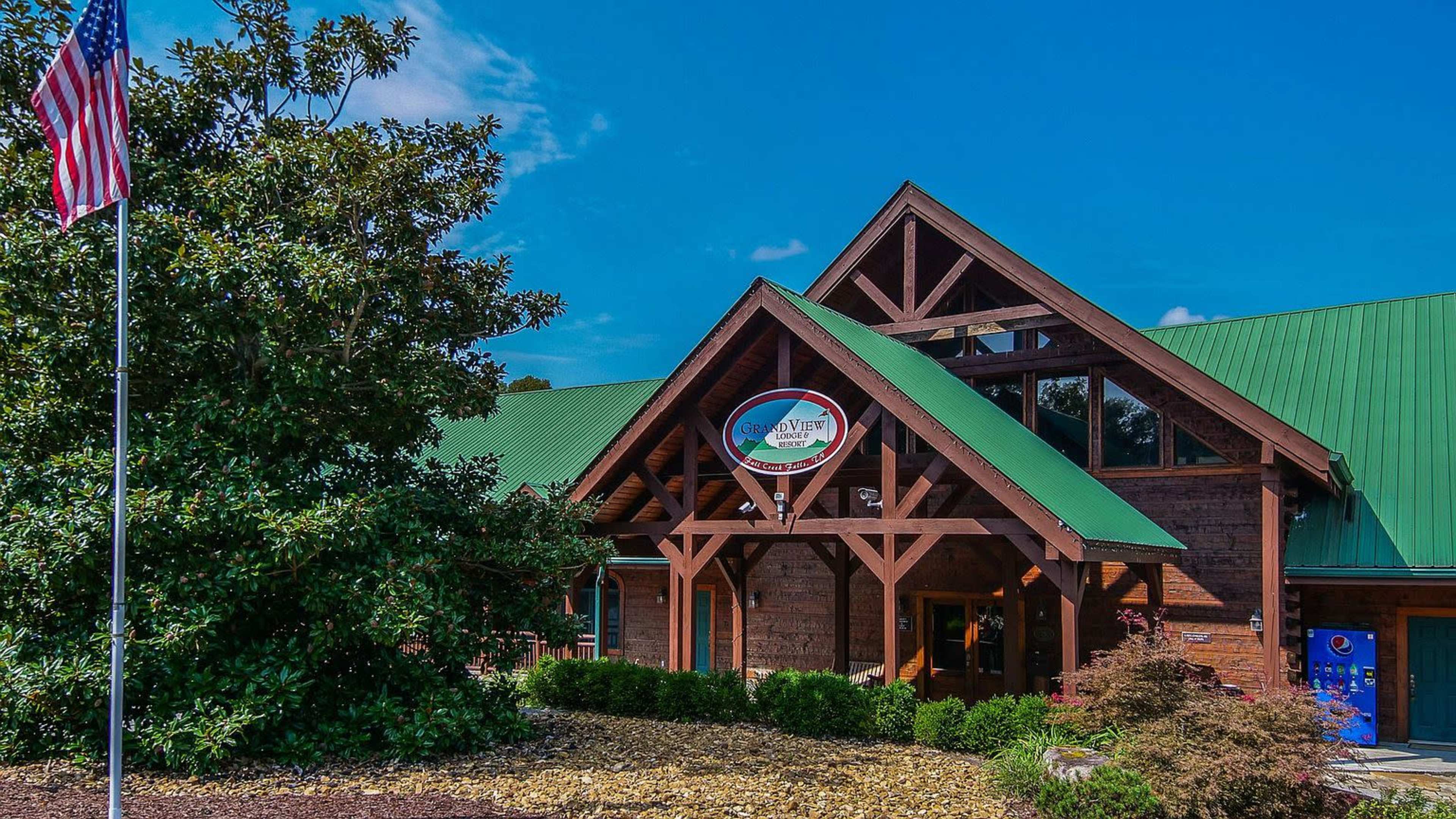 The image shows a wooden building with a green roof, featuring a circular sign and an American flag in front.