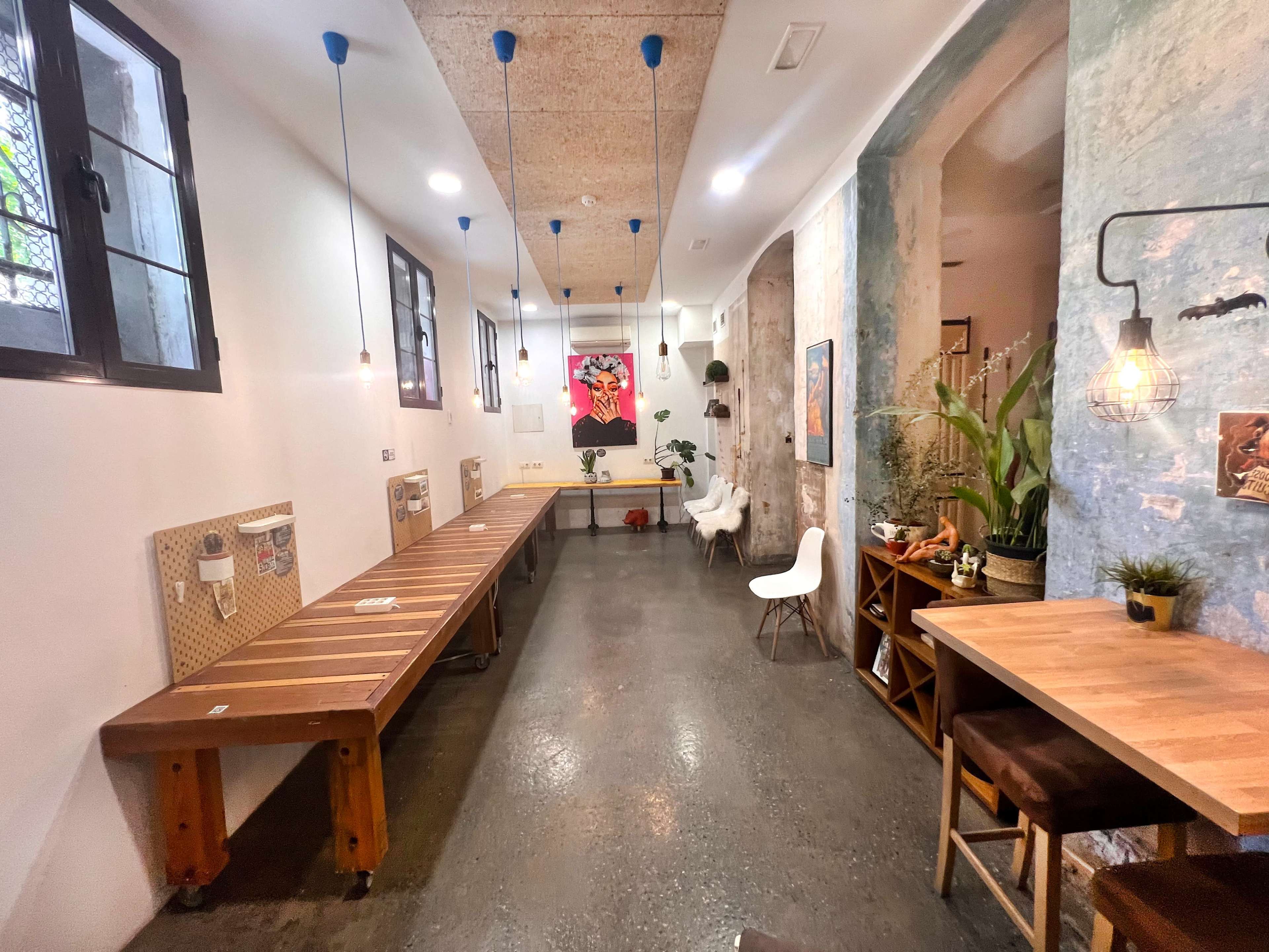 The image shows a modern interior space with exposed brick walls, wooden tables, and pendant lighting, creating a cozy atmosphere.