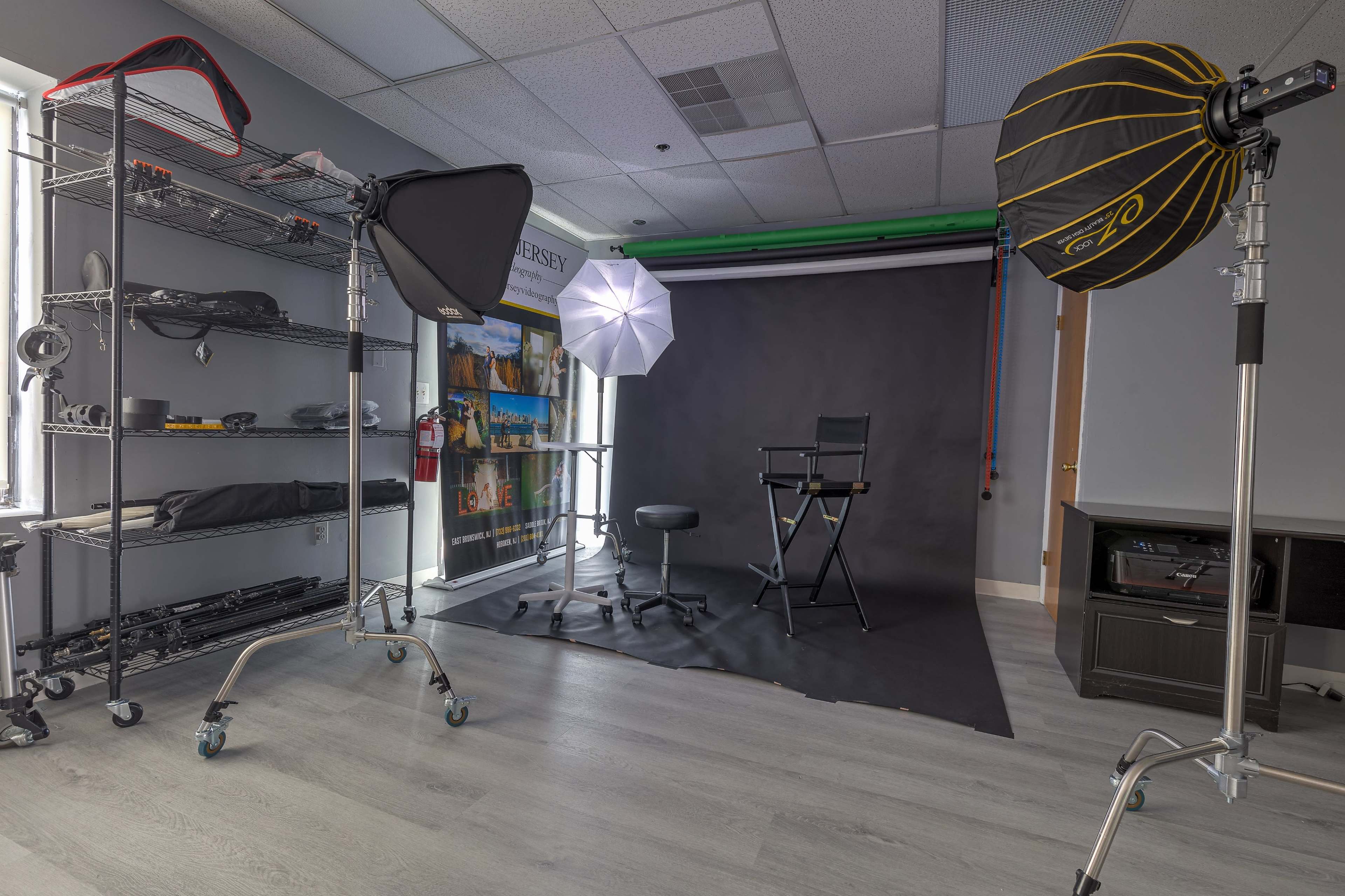A photography studio setup with lighting equipment, a chair, and a backdrop.