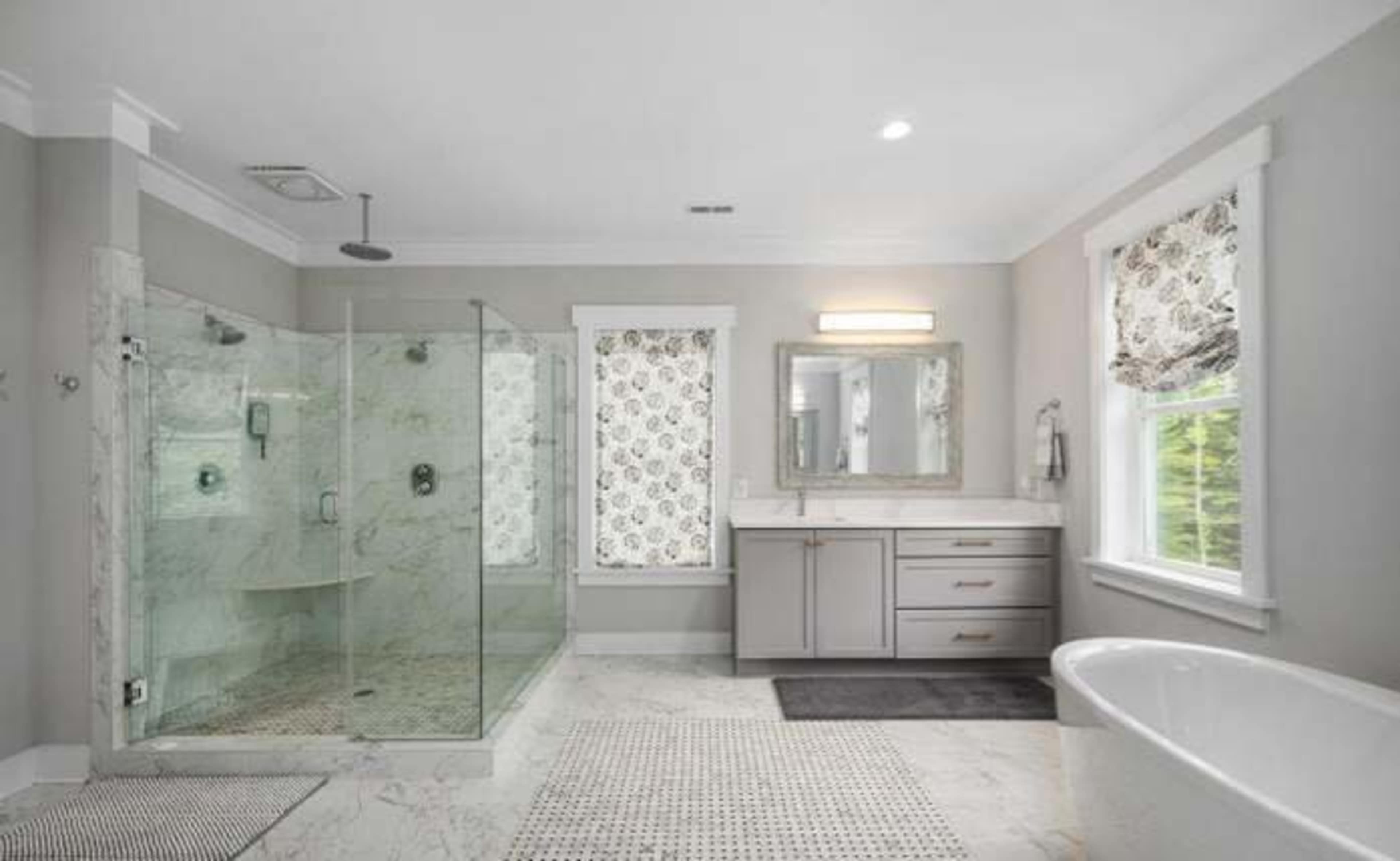 The image shows a modern bathroom featuring a glass shower, a freestanding bathtub, and a double vanity with a mirror.