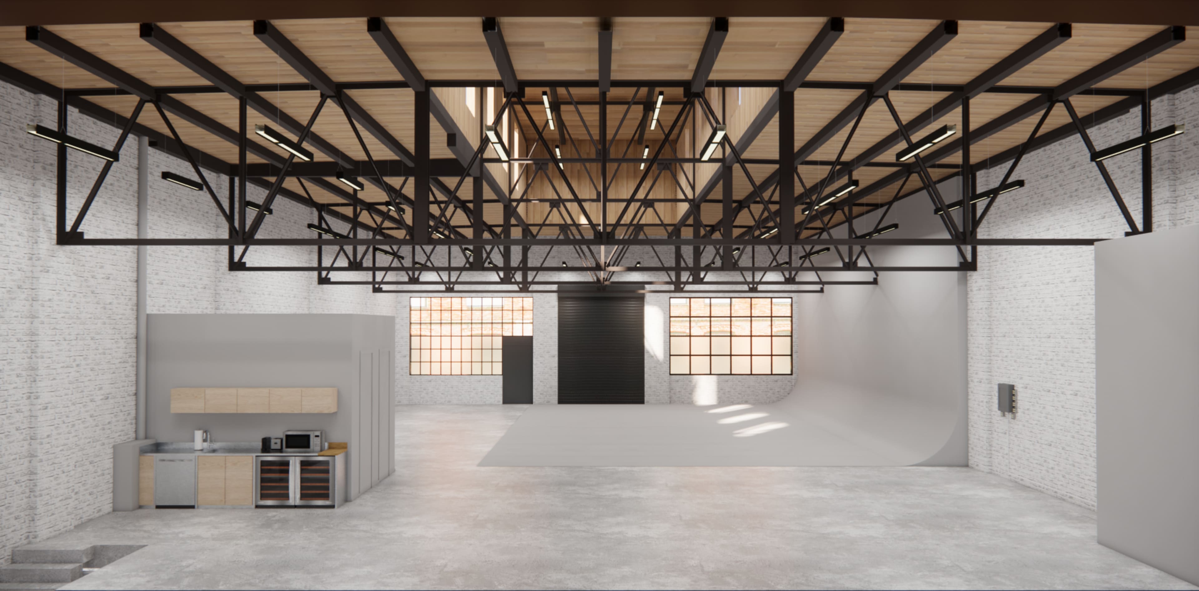 A spacious industrial studio with high ceilings, exposed brick walls, and large windows, featuring a kitchen area and a seamless backdrop for photography.