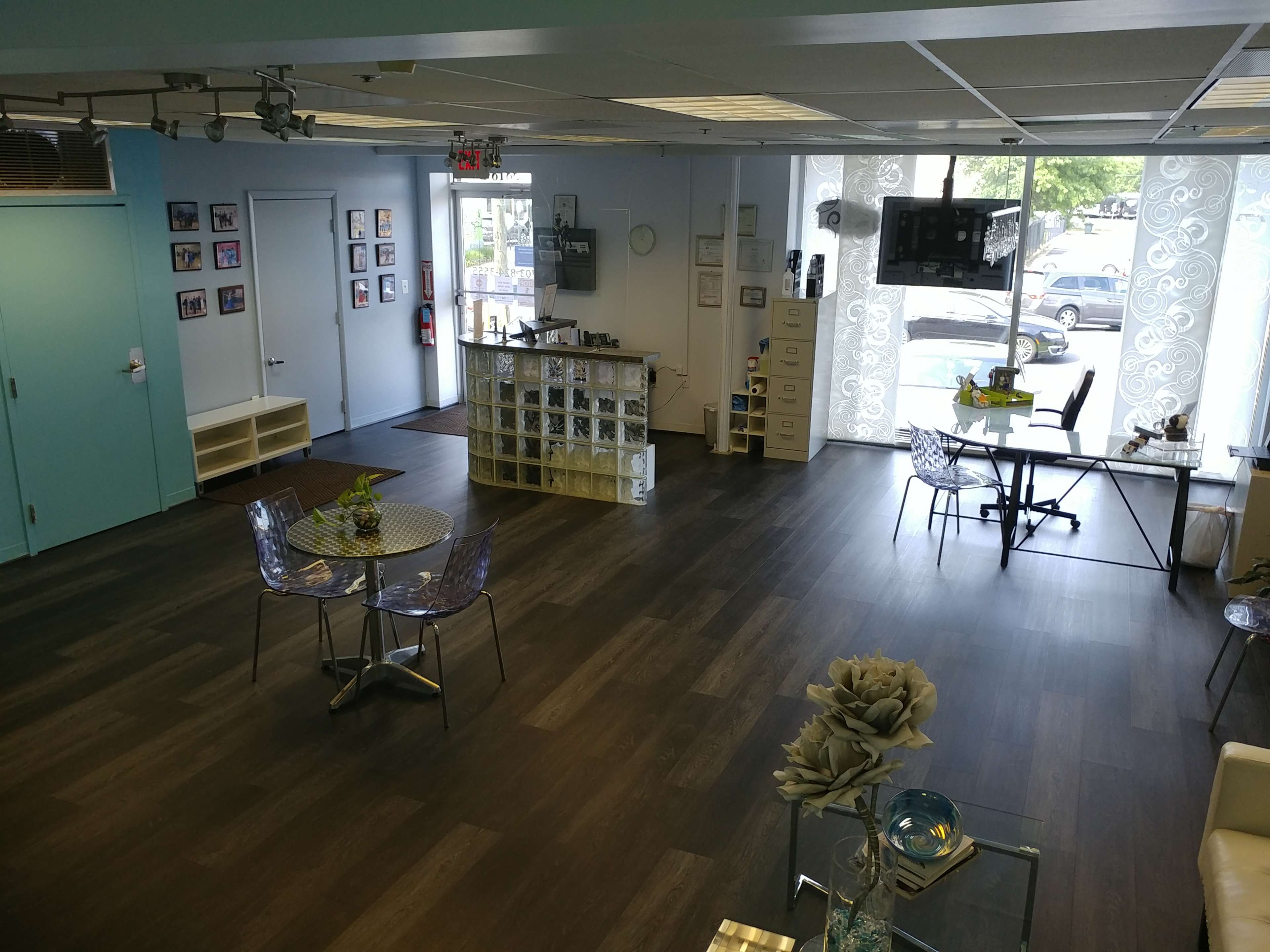 A bright, modern interior of a café or office space with seating areas, tables, and large windows letting in natural light.
