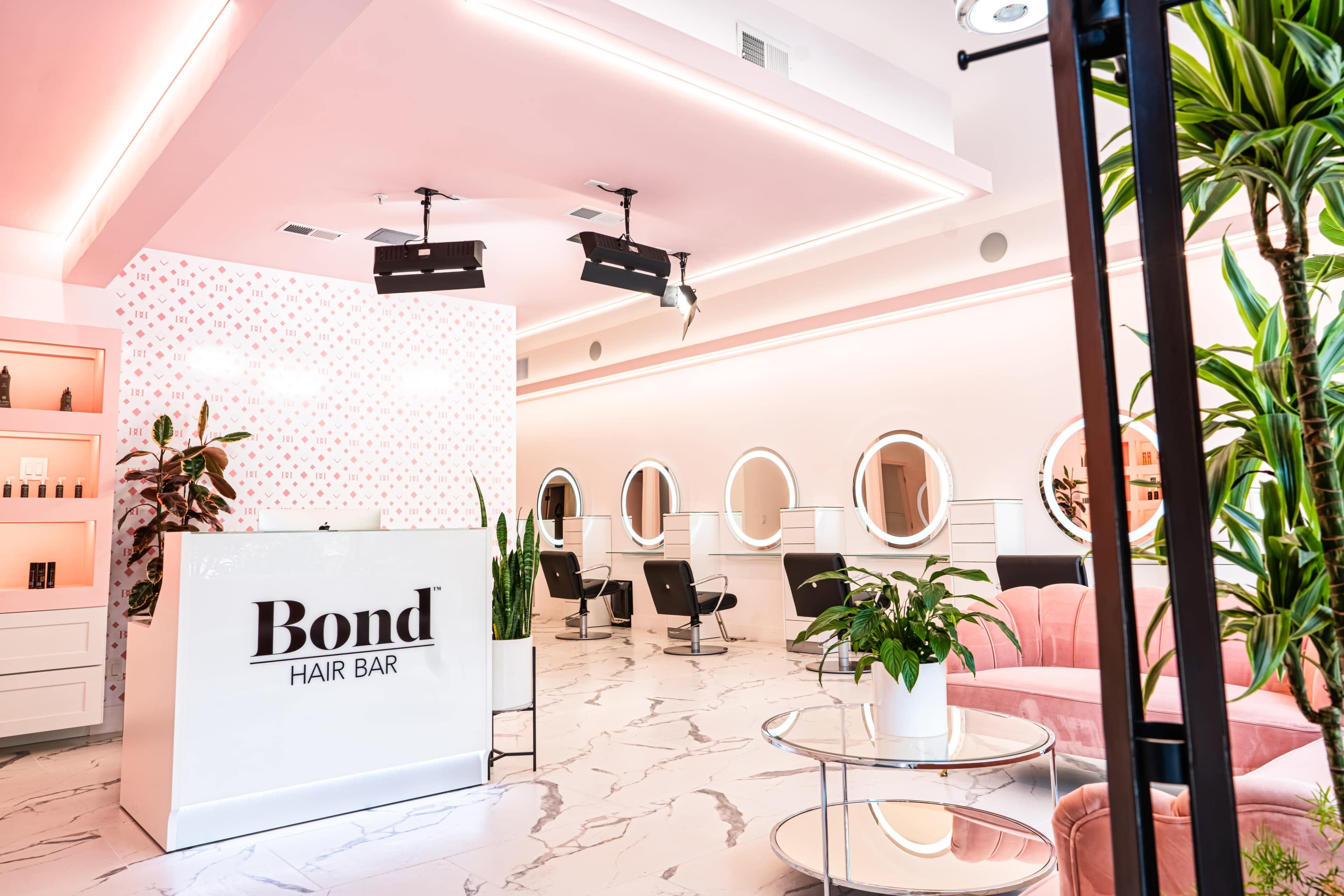 A modern hair salon with a reception area, round mirrors, and stylish seating arrangements.